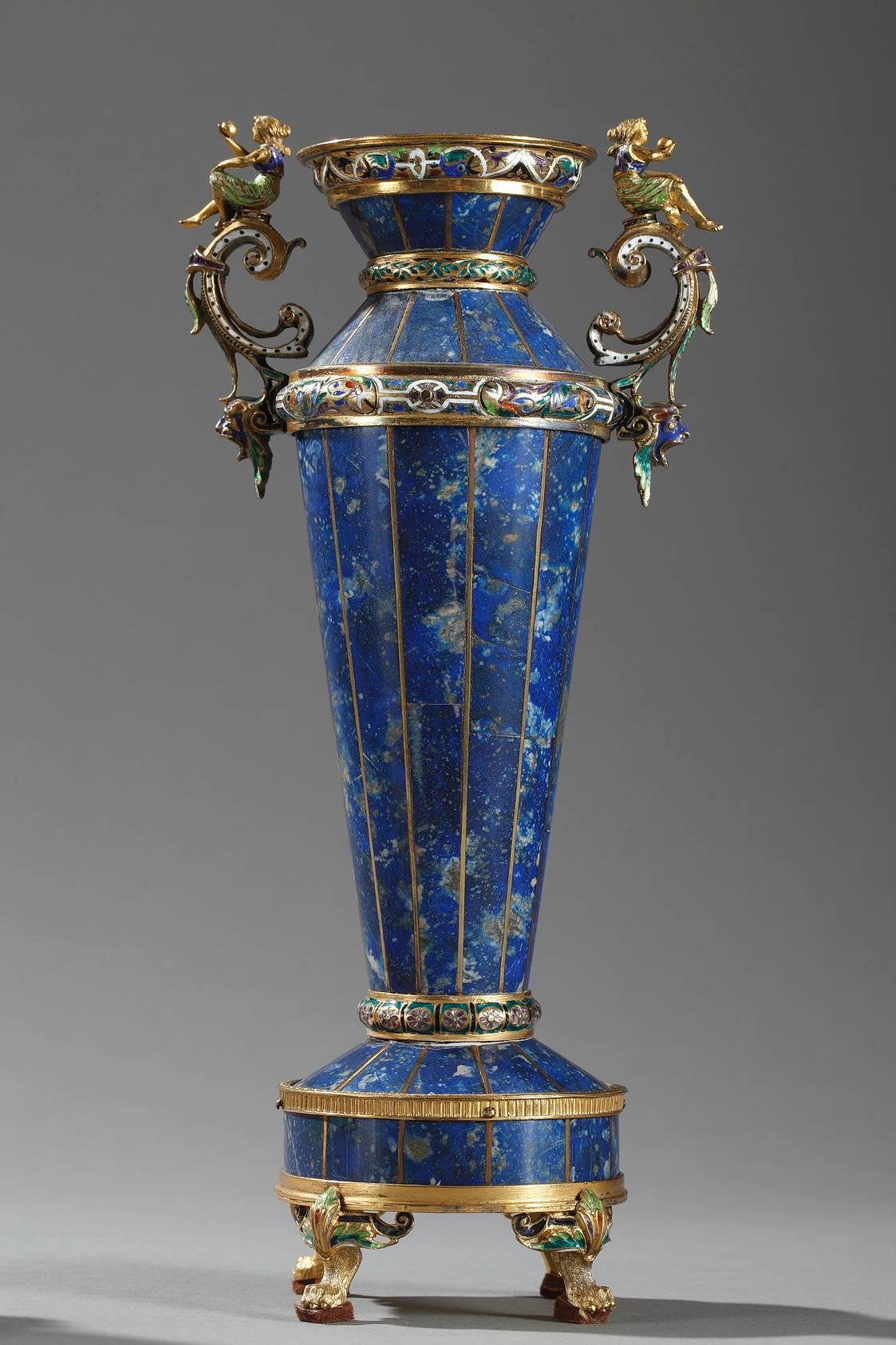 Set composed of a clock and a pair of vases with silver-gilt mounting. They are richly decorated with scrollwork, foliage, and busts of winged women. The small, circular enamel clock face is decorated with birds and rinceau. It is set on a sectioned