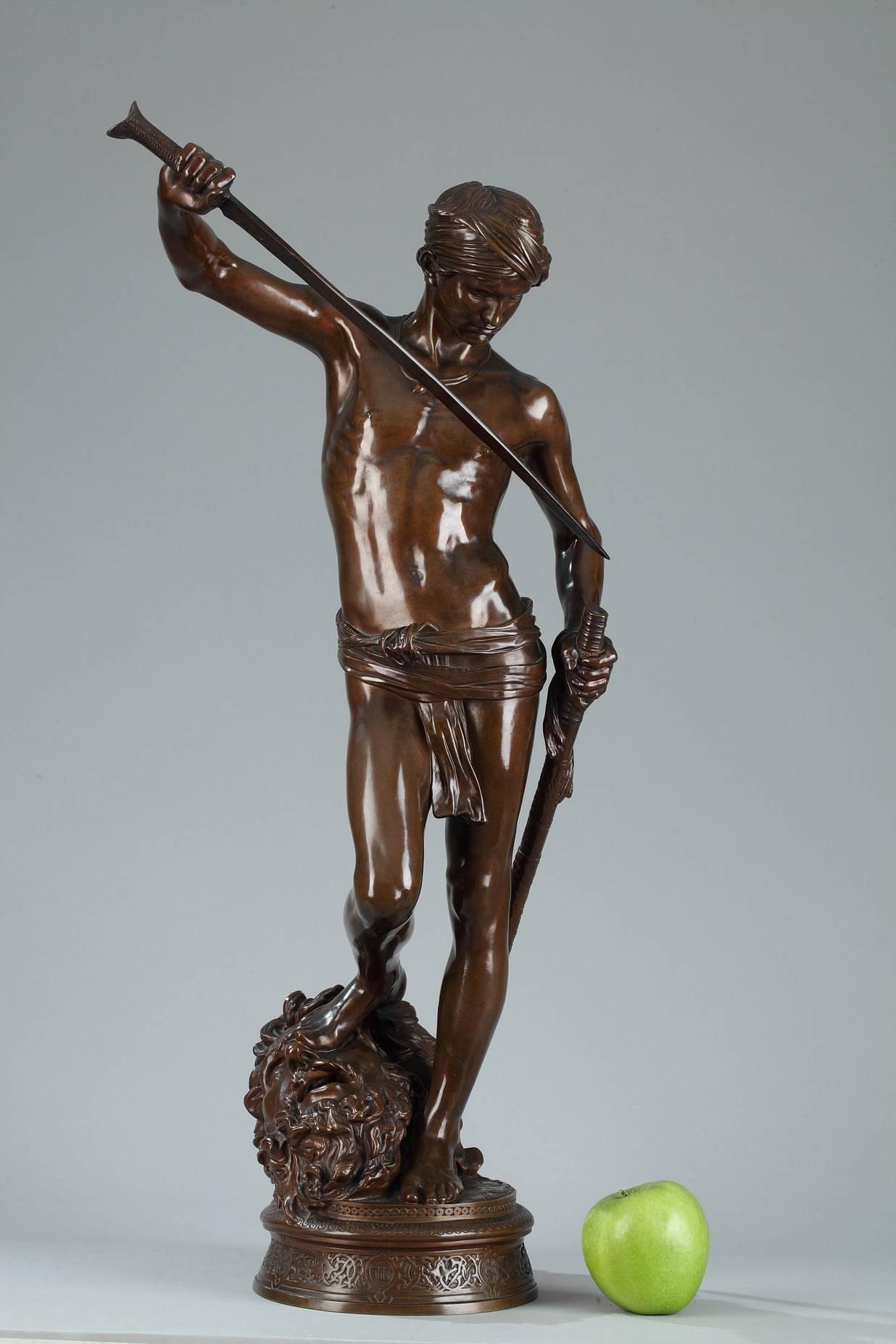 Bronze with brown patina featuring King David after conquering Goliath. The sculpture is set on a circular base and is embellished with geometric patterns and interlacing arabesques. Signed on the base: A. Mercié. Barbedienne foundry, mechanical
