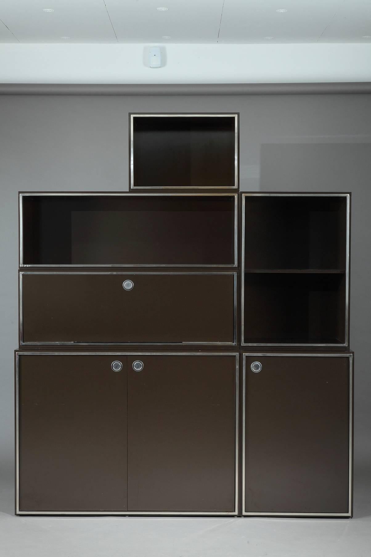 Willy Rizzo (attributed to) modular wall unit from the 1970s. It is composed of two storage containers with lateral doors, one container with a flap and eight open containers, all of them decorated with silver tone metal frames. Good vintage