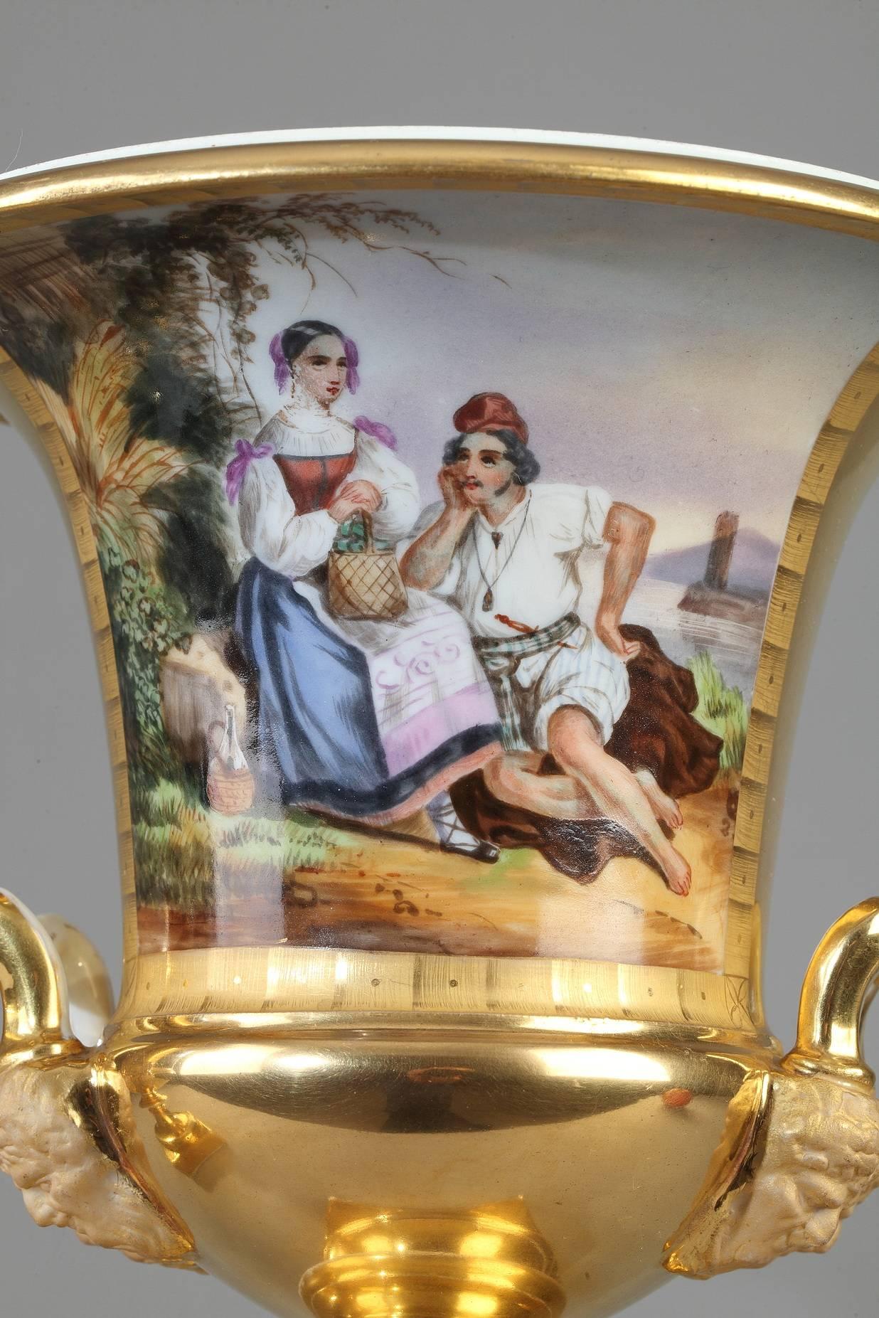 Pair of restauration Medici vases in multicolored porcelain and gold, decorated with large cartouches featuring Italian peasants on one side and Italian landscapes on the other. The neck, handles, and base are gilded. Each vase is set on a square