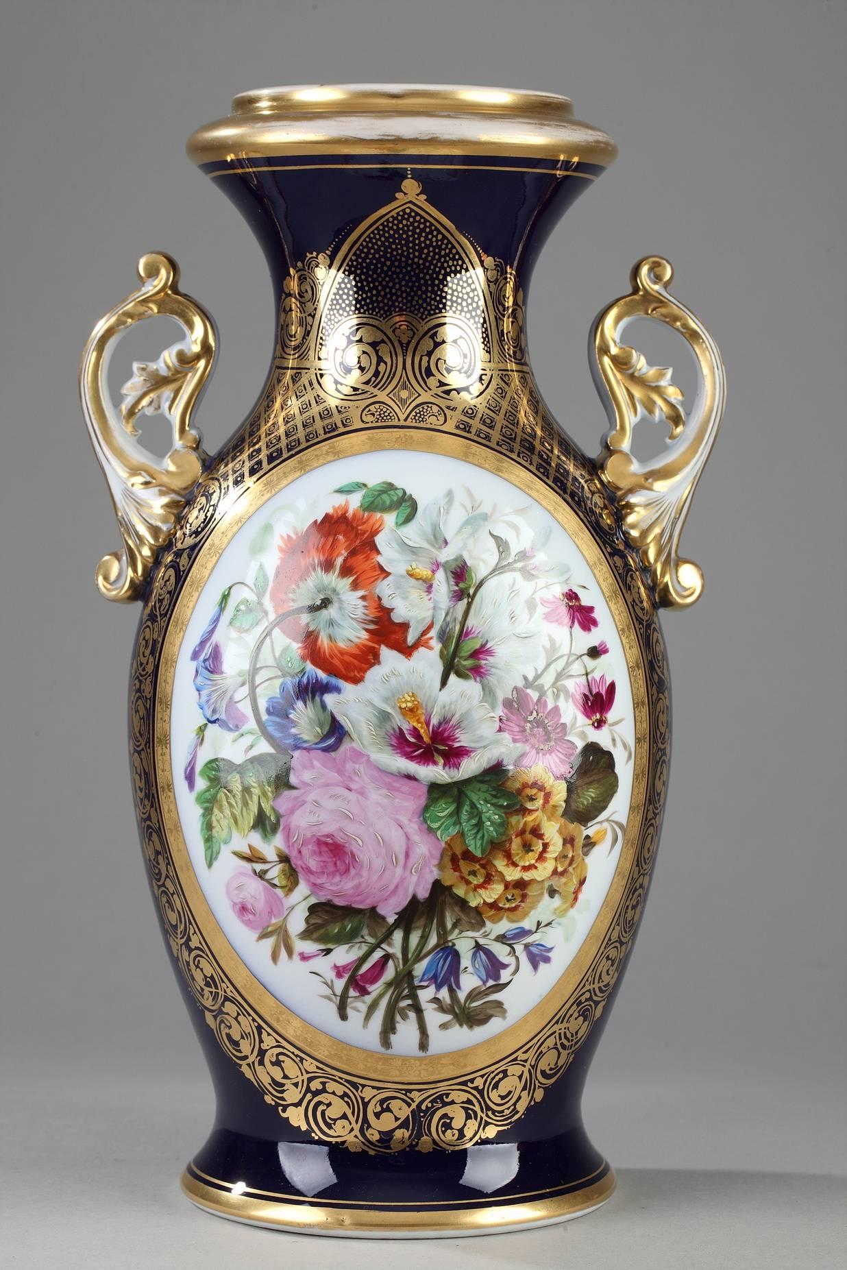 Pair of oval, porcelain vases, decorated on one side with multicolored bouquets in cartouches framed in gold. The base and the neck are accented with rinceaux, scrollwork, and a latticework pattern painted in gold on a midnight blue background. Each