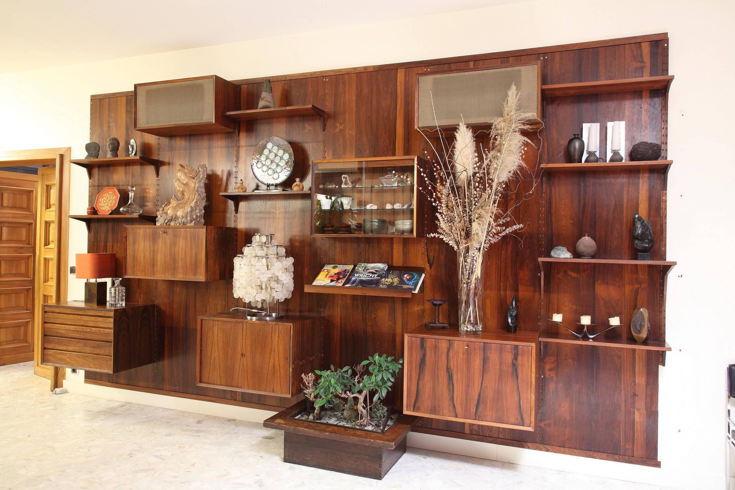 Poul Cadovius wall units system in Brazilian rosewood from the seventies. Five vertical ladders with eight shelves and six containers with wood and sliding glass doors and with drawers. Danish modern. Good condition with small traces of