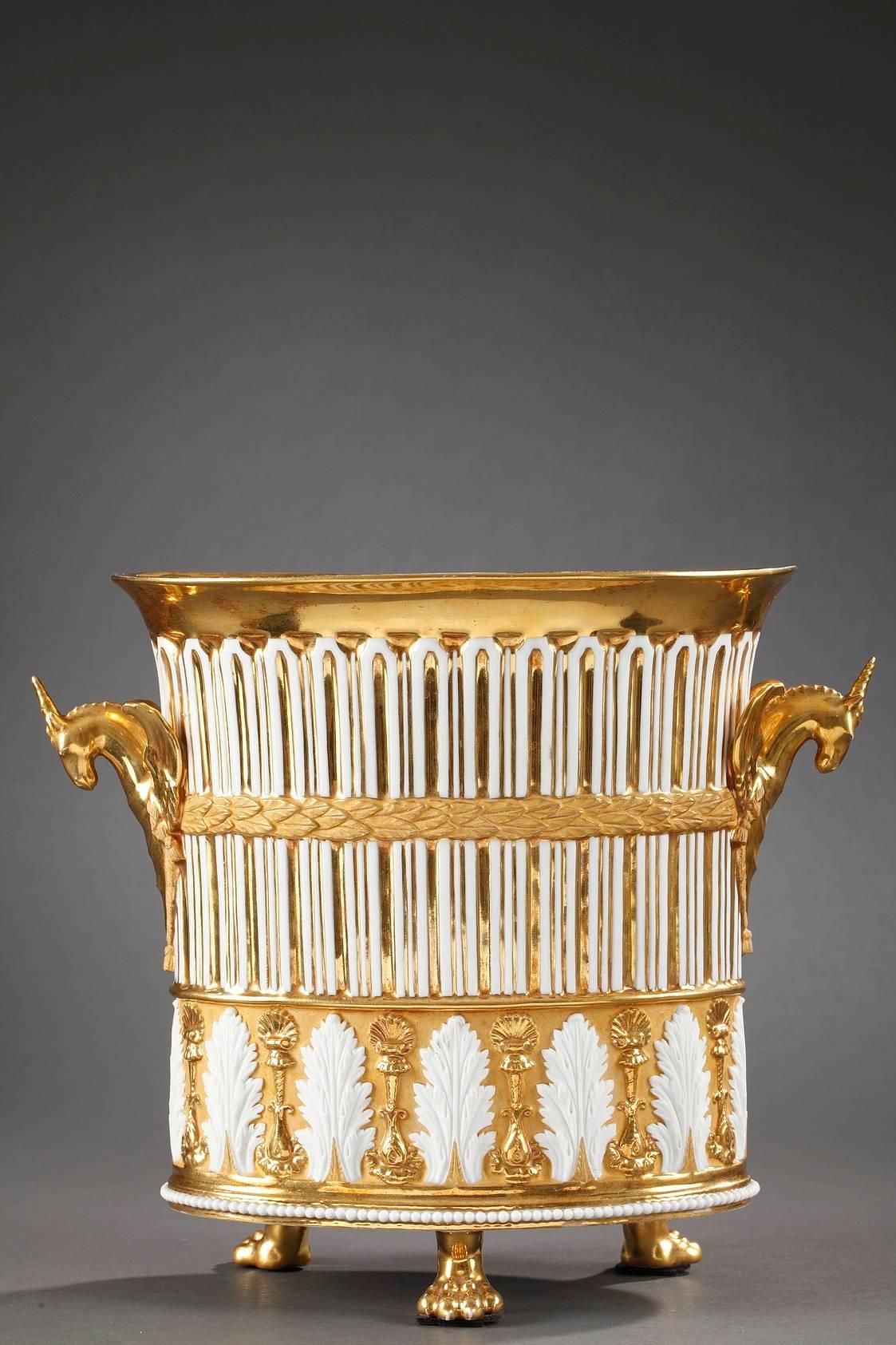 Vase-shaped mantel clock in gilded porcelain. Breguet hands track the hours and minutes on white, enamel dial with hours marked in Roman numerals. The porcelain is interspaced with gilding to form fluting on the body, and below the fluting are