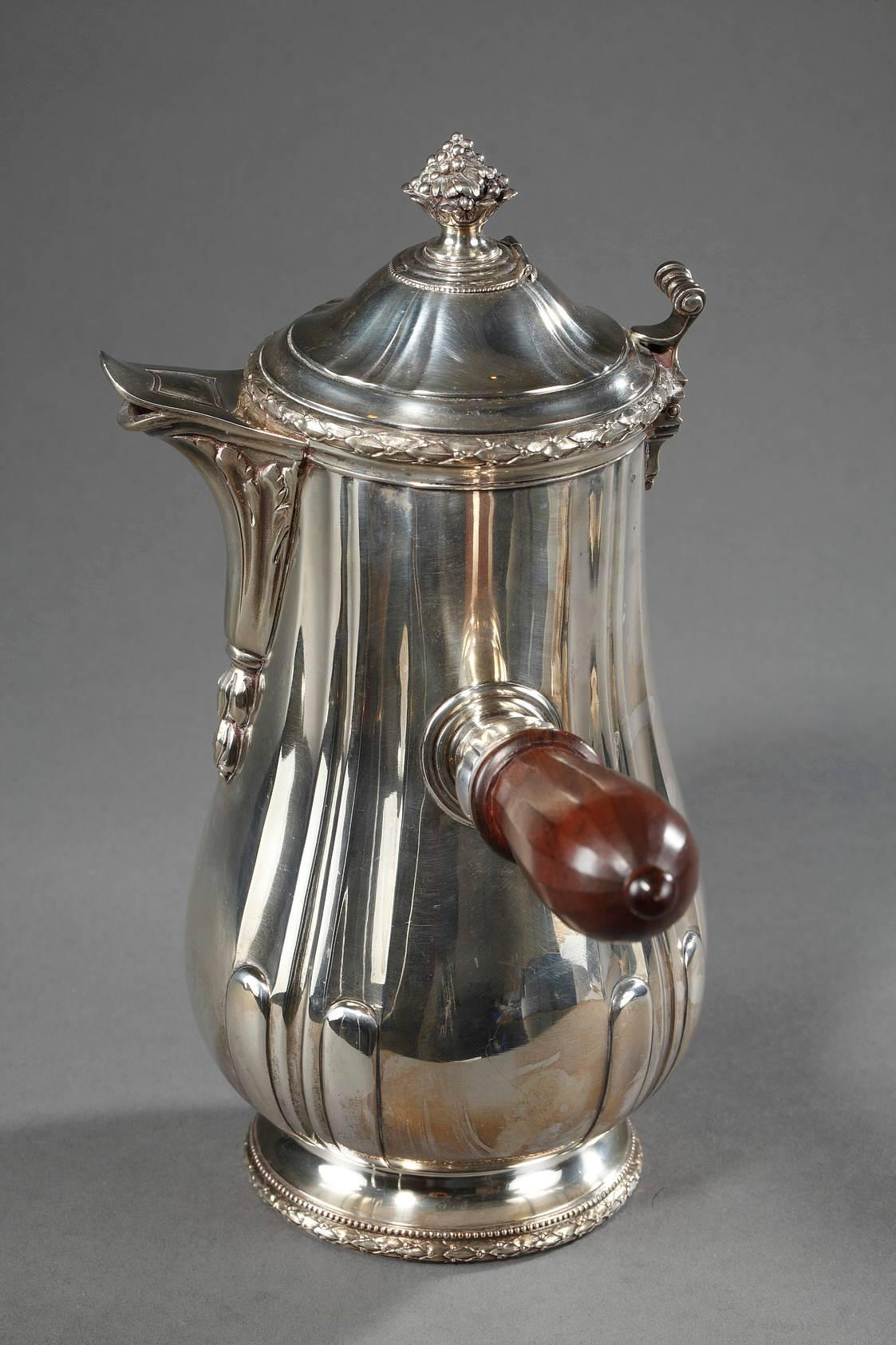 Silver hot chocolate pot decorated with laurel garlands and gadroons. The lid is topped with a fruit bowl, and a rosewood handle is attached to the side. French Minerve silver mark. Silversmith: Puiforcat in Paris, 


circa 1930
Dimensions: W: