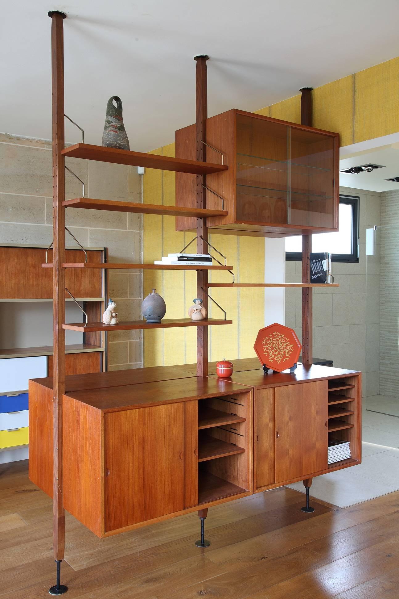 Poul Cadovius Royal system floating wall unit in teak, composed of three vertical ladders, six shelves and six cabinets with sliding doors, multiple shelves and compartments inside. Extensible high from 242 cm to 256 cm. Designed by Poul Cadovius