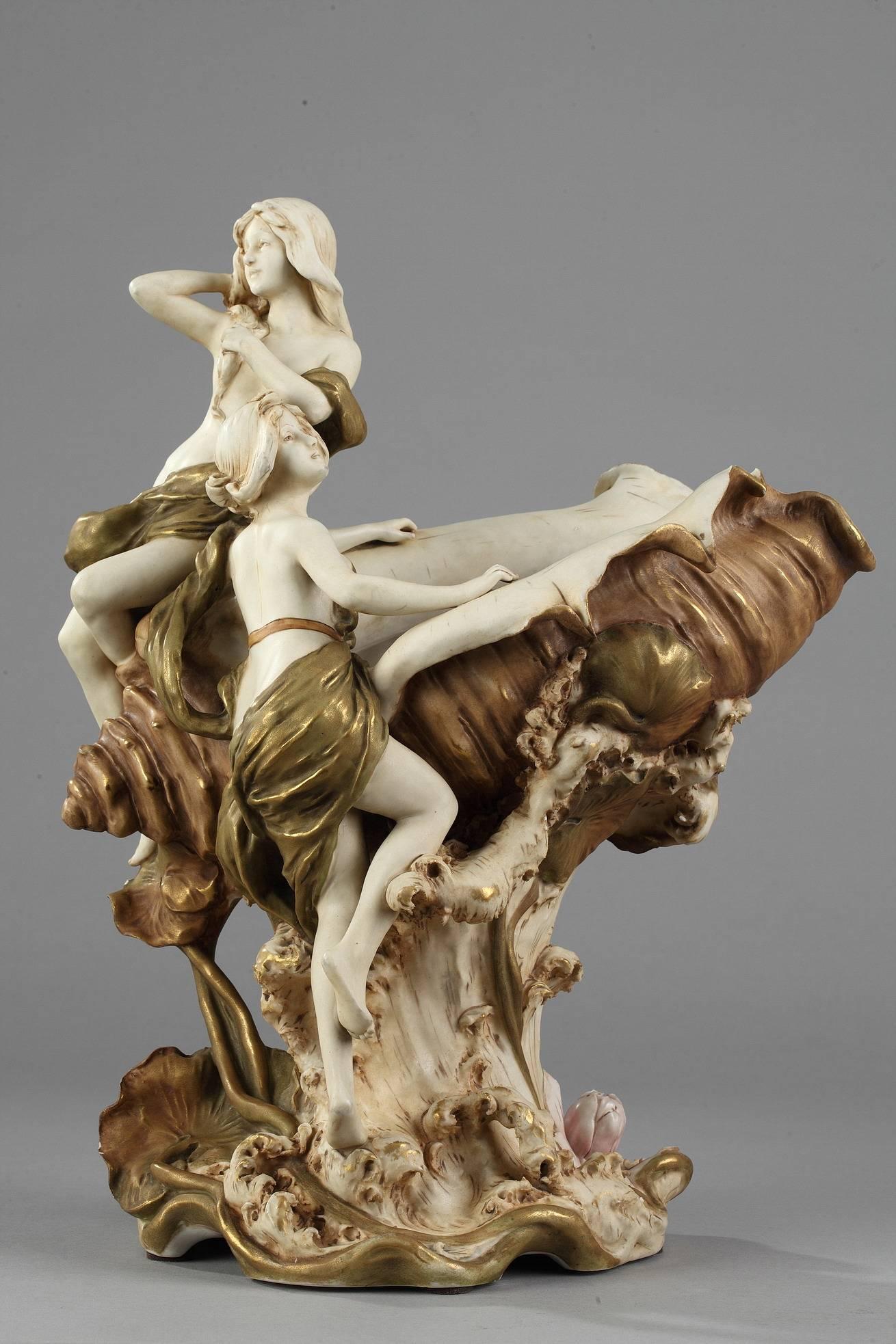Royal Dux? Porcelain? Centrepiece composed of a large pair of vases and a central figural group depicting two women on a conch shell. The vases are decorated with aquatic plant motifs. Stamped with the pink, triangular Royal Dux Bohemia hallmark and