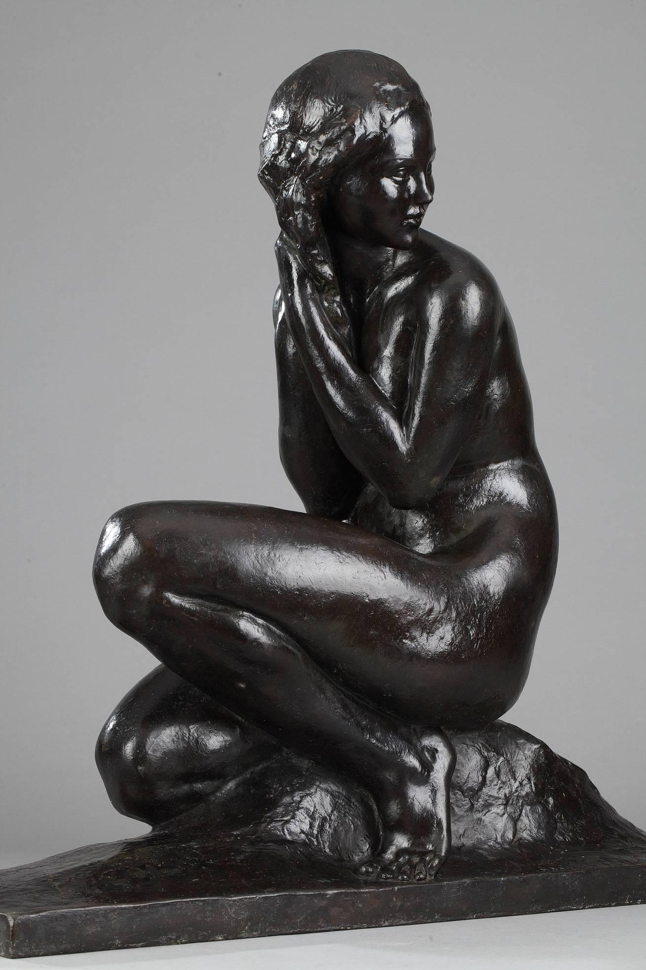 Art Deco patinated bronze sculpture depicting a crouching woman resting on a rectangular base. Signed 