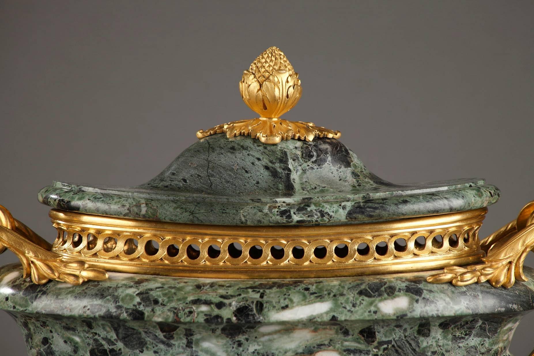 Green marble, ormolu-mounted incense holder on a gilt bronze, square plinth. A pine cone serves as a handle for the lid, which rests on an openwork, interlacing frieze. Two handles which culminate in scrolling foliage run down the sides to the top