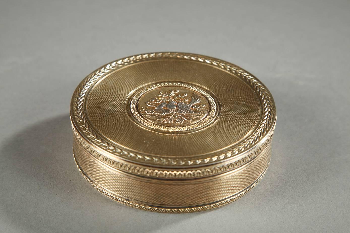 Round, silver jewelry box with silver-gilt interior. It is very intricately engraved with latticework and hemmed by friezes of interlacing and foliage. The lid is adorned with a central medallion representing a dove on a quiver surrounded by flowers