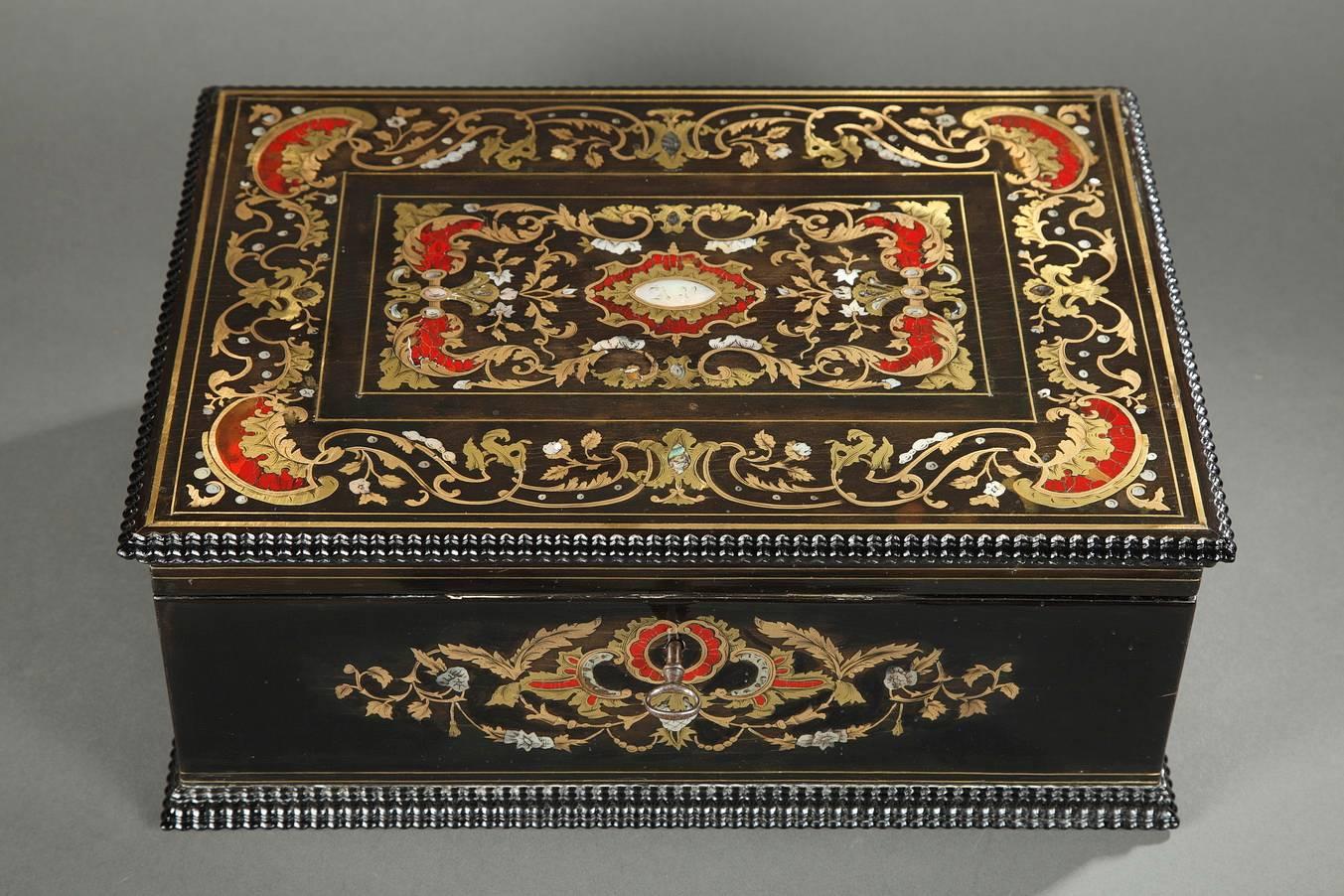 Sizeable rectangular, wooden coffer with its key. The blackened wood is inlaid with mother-of-pearl, tortoiseshell, and brass. The lid and the main face of the box are richly decorated with gilded rinceau, flowers, and scrolling vegetation. The