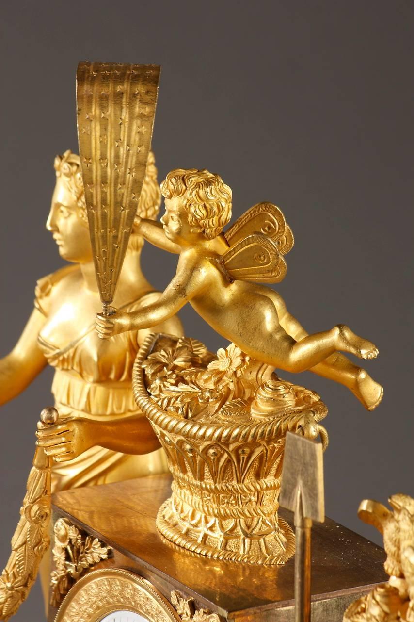 Restauration gilt bronze mantel clock with figures of a young woman and Cupid. The woman is wearing a classic tunic with an Empire waist, her face is turned slightly to the left, and she is holding a garland of flowers in her hands. A winged Cupid