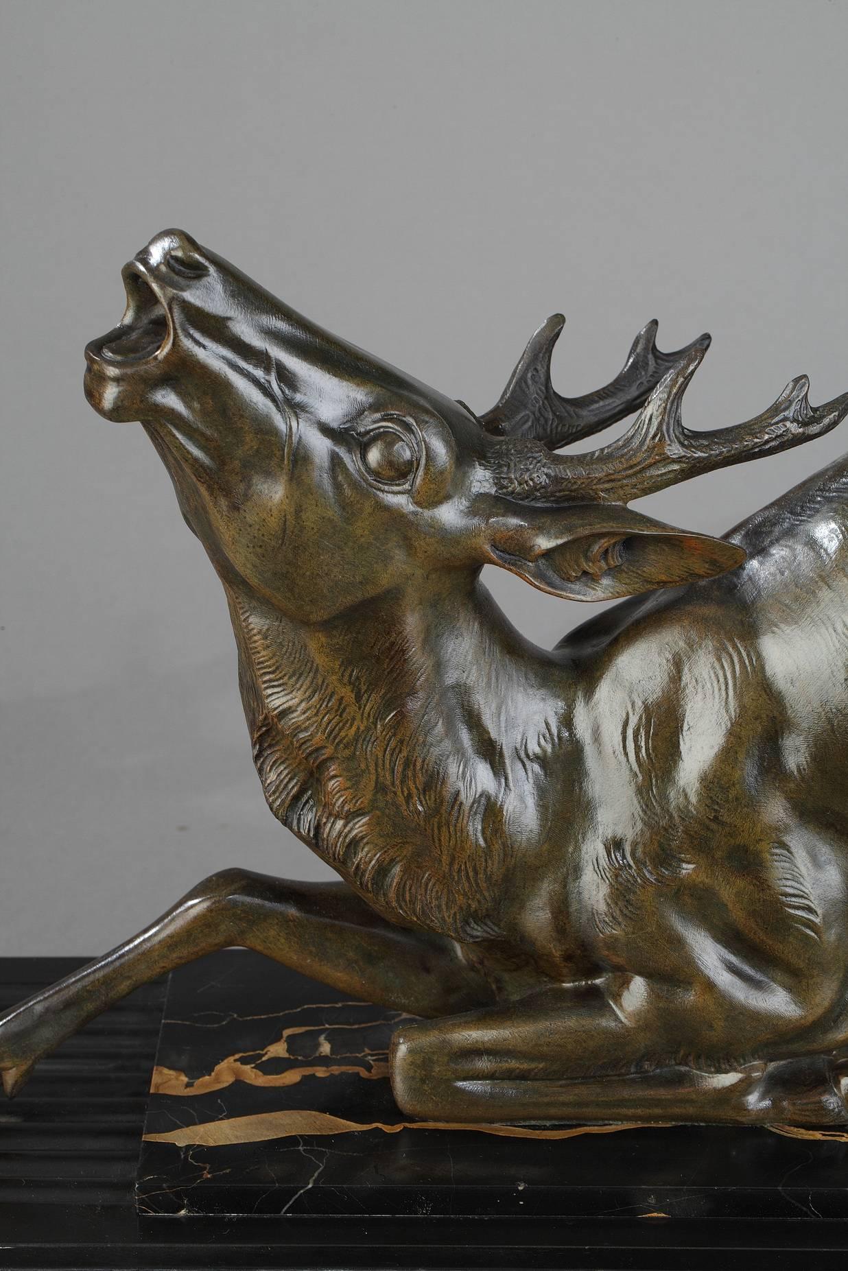 Large Art Deco patinated bronze sculpture of a fallen stag, featuring very probably a hunting scene. The stag is realistically sculpted, embodying movement. In using precision and Fine details, Hugonnet brings to life the anatomy and fur coat of