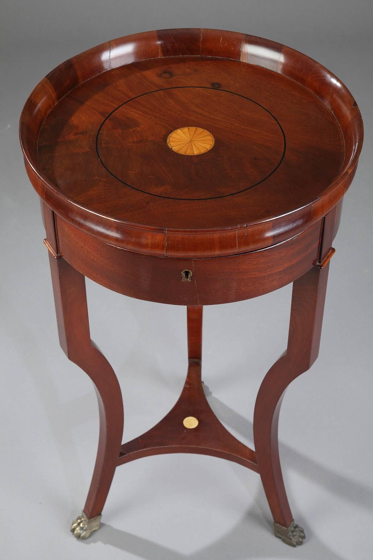 Small work table-jewelry box in mahogany and mahogany veneer with rosette marquetry inlaid lift top. It is provided with a mirror and a fitted compartment inside (H 4 cm). The table is set on three curved claw feet in gilt bronze. Restauration