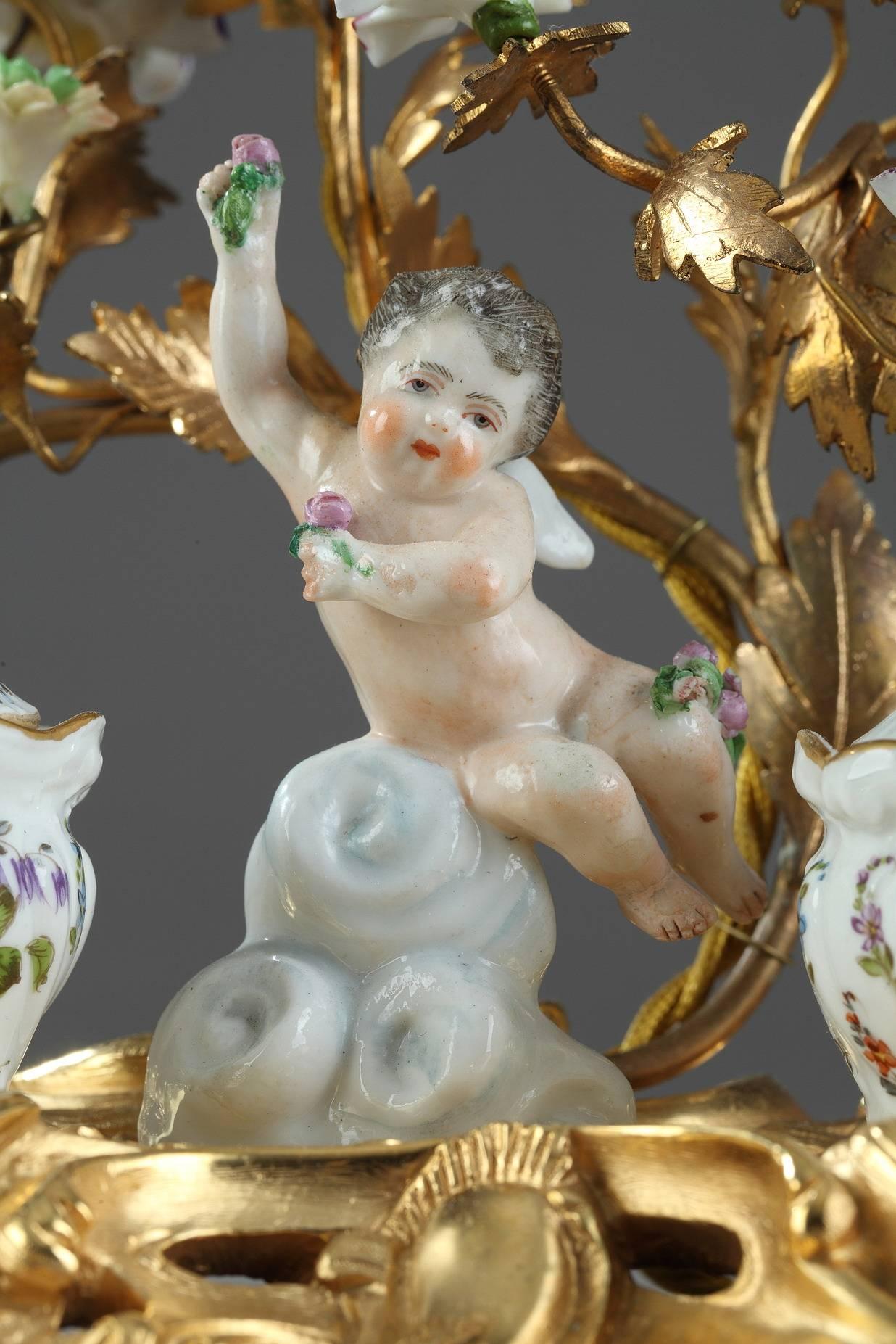 Late 19th century multicolored porcelain and ormolu inkwell in Meissen taste.
This piece is very representative of Louis XV style, with its rich decoration of multicolored flowers, ormolu branches, foliage and Rocaille motifs. A putto on a cloud