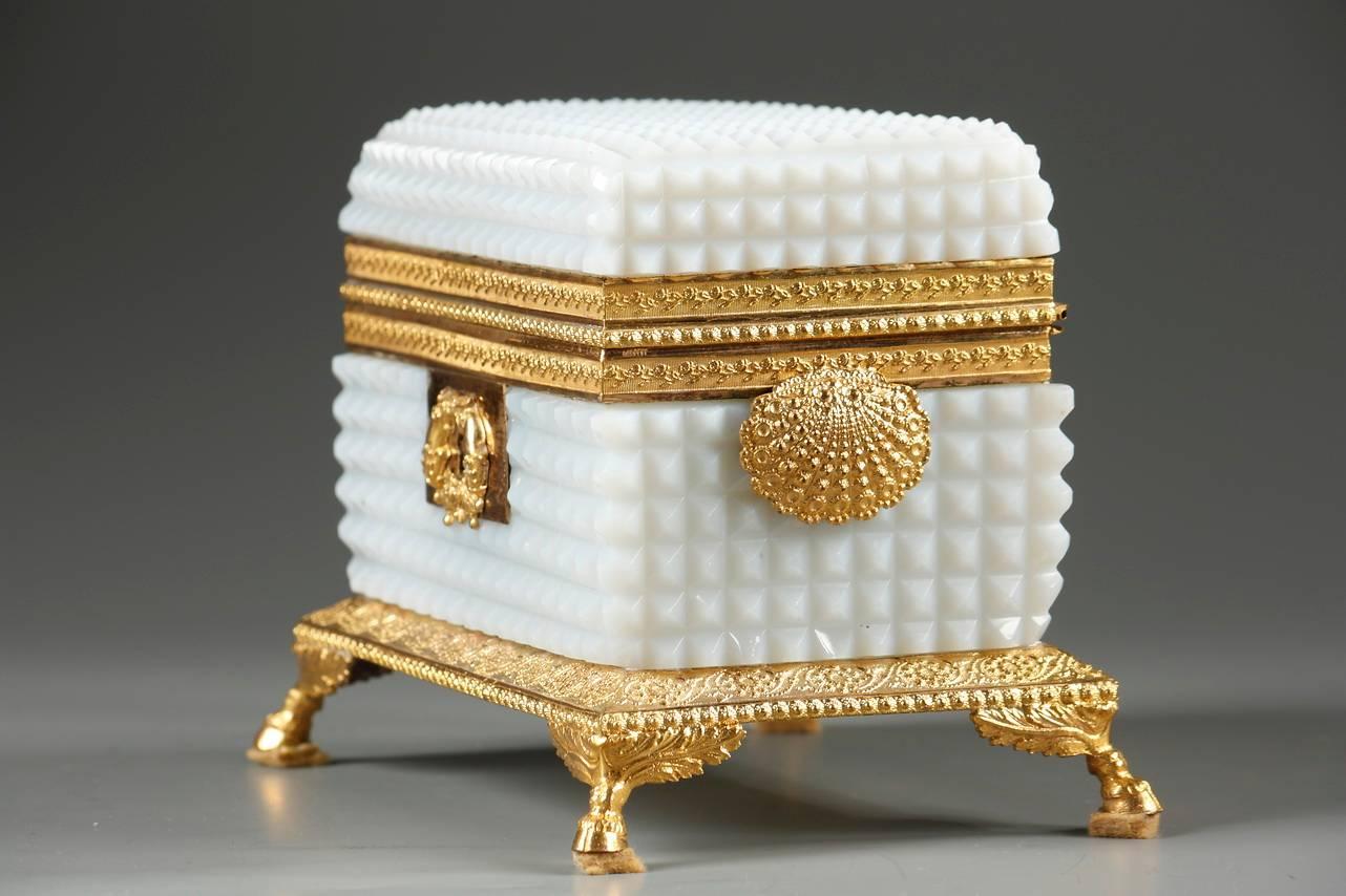 Rectangular jewelry box in white opaline and gilt bronze mounts. The chiselled diamond pattern of the box was very popular during the Charles X era. The mounts are engraved with friezes of flowers and flowering branches. The key plate is decorated