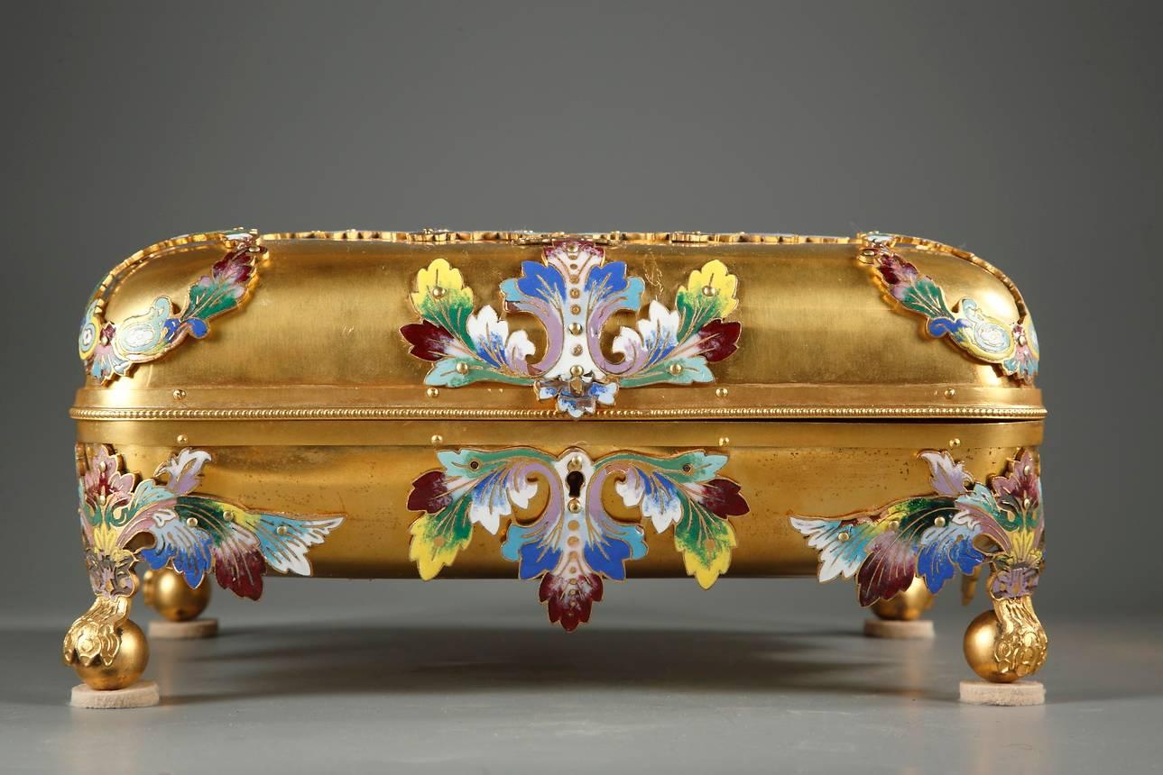 Sizeable gilt bronze and champleve enamel ‘casket’ with its key, resting on four ball-shaped feet. The entire surface of the box and lid is engraved with champleve crowns, acanthus leaves, and multicolored foliage. In the front and centre of the lid