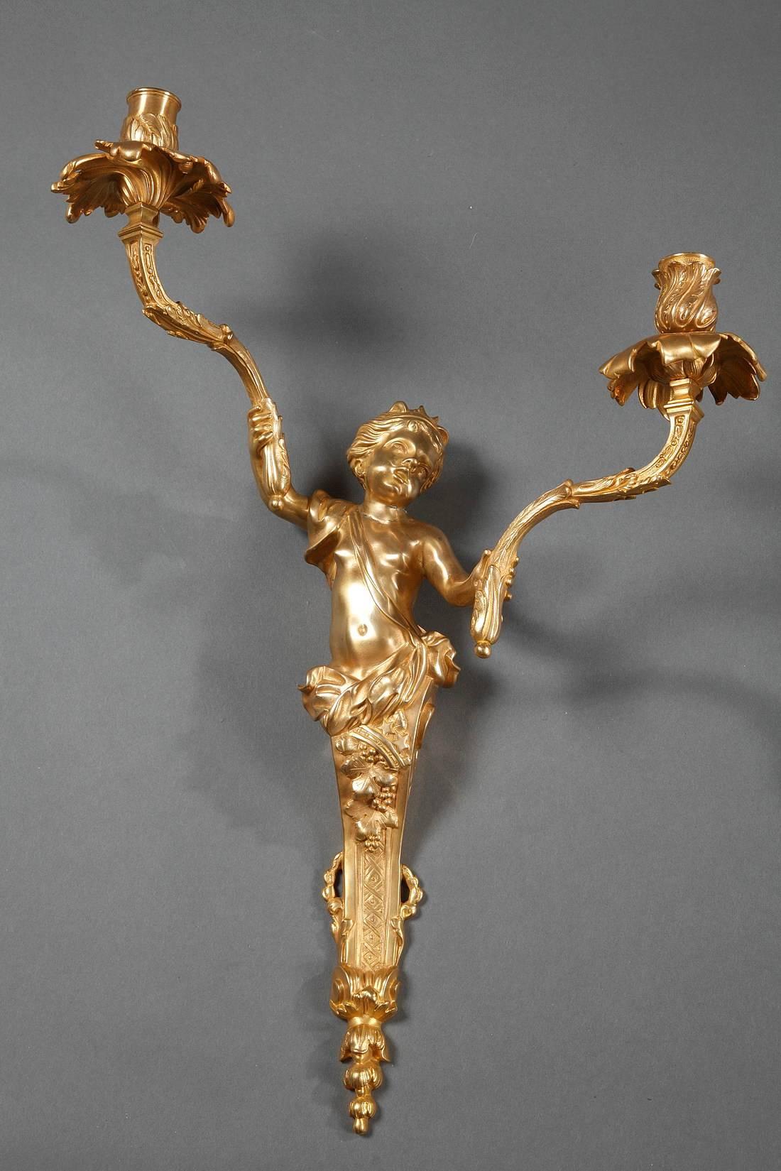 Pair of Napoleon III ormolu sconces in Louis XV style. Each sconce is decorated with a child wearing flowing garments and holds in its arms the candlestick arms. The nozzles are decorated with lively foliage,

 
circa 1860
Dimensions: W 15 in, D