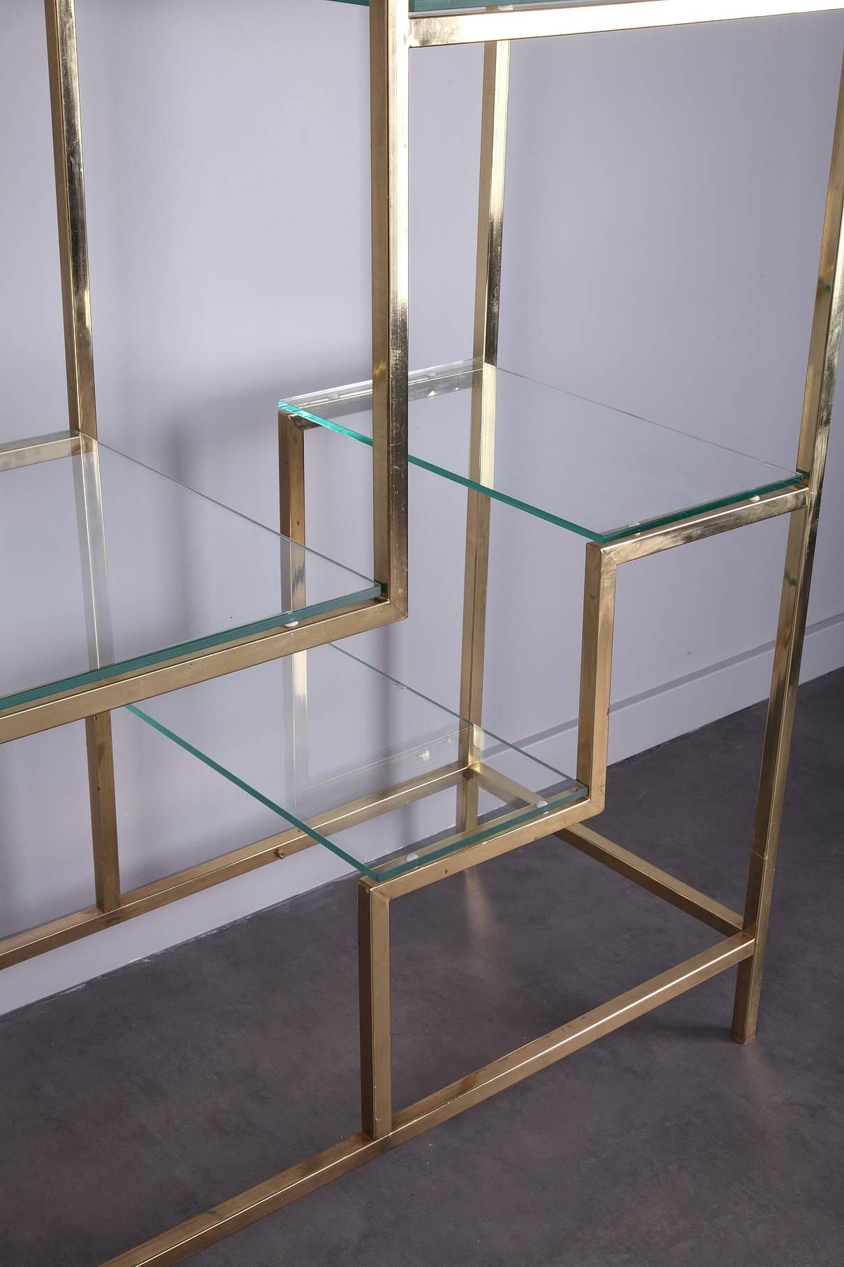 Large brass bookcase by Kim Moltzer (1938-2015) from the 1970s. It has a beautiful sculptural geometric form, finished in brass, which support 12 glass display shelves and a further central display niche that adds a strong central focal point. Good