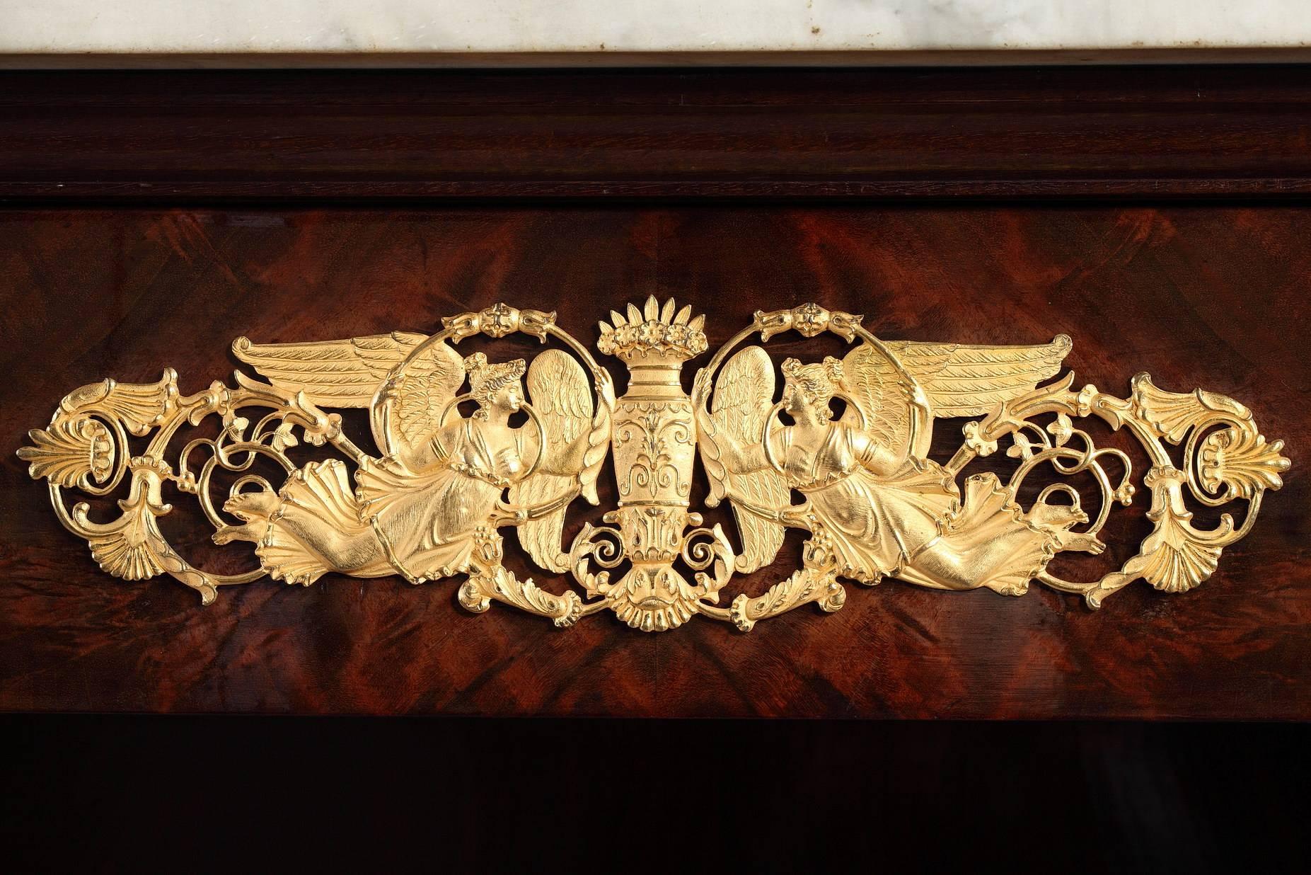 An exquisite Empire mahogany console set on two straight legs in the back and two swirl shape legs in the front, ending with gilded bronze claw feet.
This console has a drawer, it is topped with a white marble top and decorated with beautifully