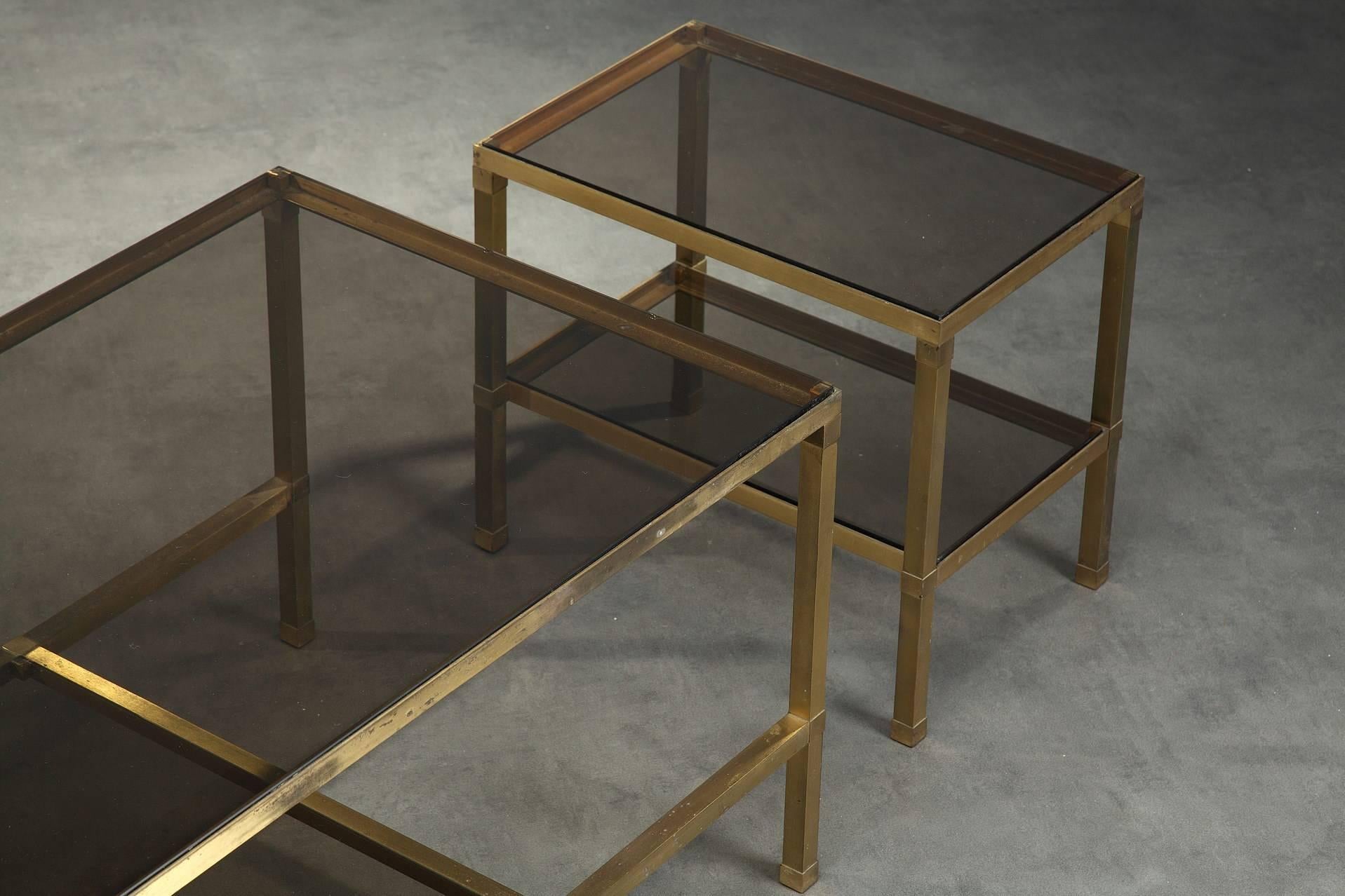 Gilt bronze coffee table composed of three nesting tables. Each table is provided with two smoked glass trays. Attributed to Maison Jansen (Paris, 1880-1989). Good vintage condition, with some oxidation on the metal, circa 1970.
Measures: Big table