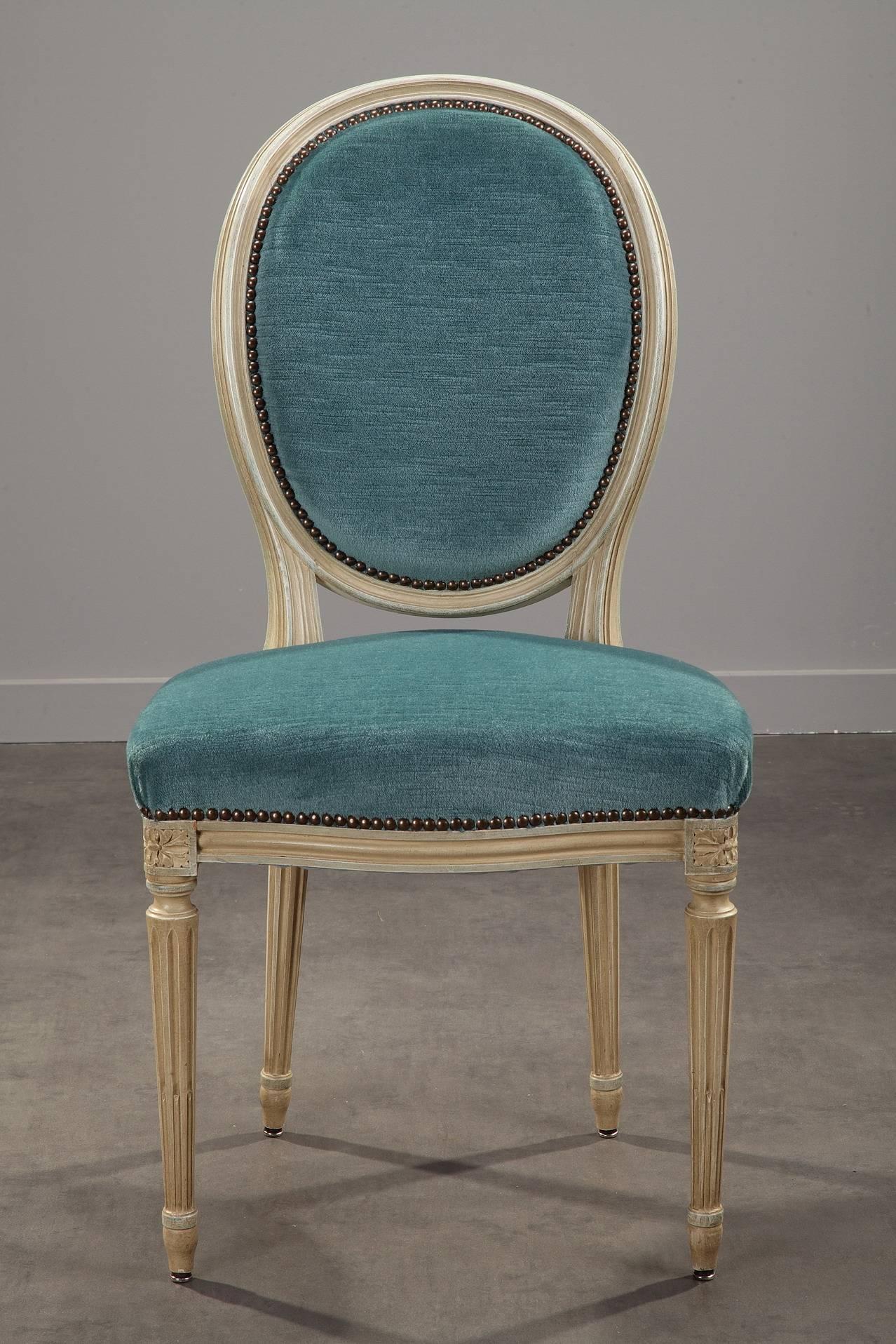 Set of eight blue velvet reupholstered chairs with green-grey lacquered structure. Each chair is set on four fluted legs, the most typical feature in the constructional details of Louis XVI furniture. The wooden structure is decorated with flutes