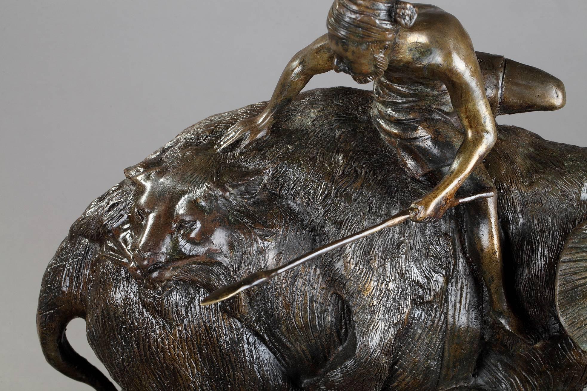 Early 20th century patinated bronze sculpture featuring a hunter with his lance, on the back of an elephant. The man is sitting on a lion skin and seems to fix the crocodile hidden behind a rock, in front of him. Signed 
