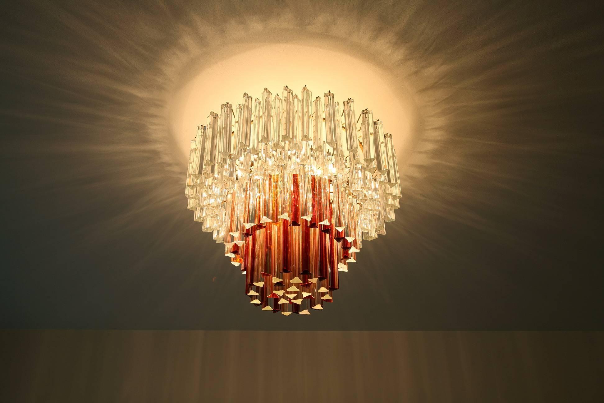 Circular ceiling lamp designed by Paolo Venini (Italian, 1895–1959) in the 1960s, with long red, orange and transparent Murano glass crystals on gilded metal mounts. Complete,


circa 1960.
Dimensions: W 23,6 in, D 23,6in, H 21,7in.
Dimensions:
