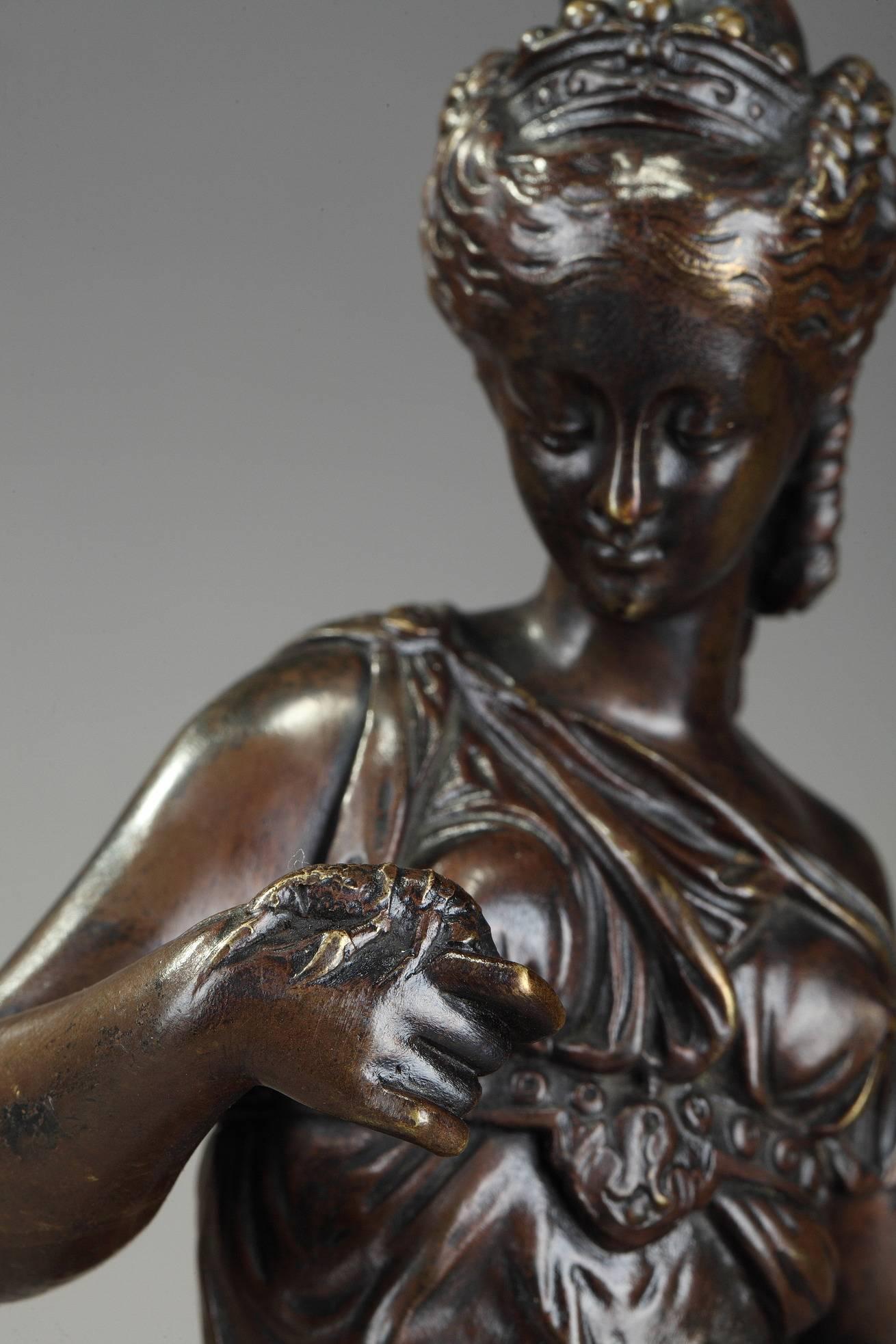 Napoleon III mantel clock decorated with a patinated bronze sculpture featuring a woman wearing a flowing robe, holding a fishing net and looking at a shrimp on her hand. Signed on the base: Paul Dubois. The sculpture is resting on a dark wooden