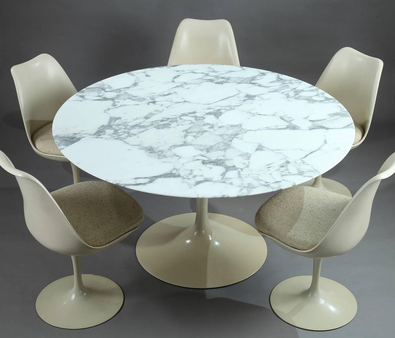 The Tulip dining table was designed by Eero Saarinen and was published by Knoll International. The upper part is a circular white arabescato marble. It is resting on a beige lacquered leg which is wider and circular at the bottom.

Set of five