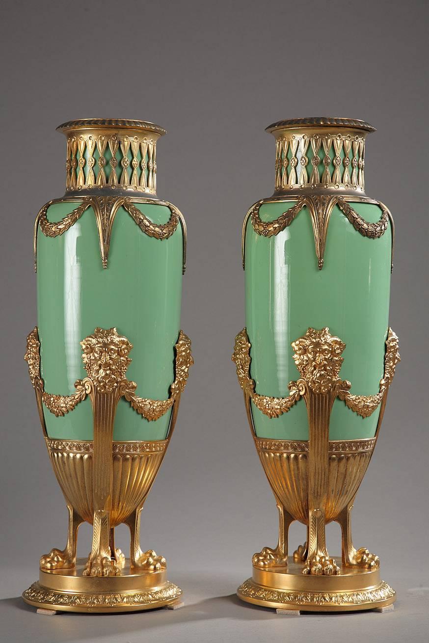 Sizeable pair of baluster-shaped vases in jade-green opaline and gilt brass mounts. Each vase is crowned with an openwork gallery in golden brass that descends to the body of the vase in the form of draping laurel garlands. The slender body is
