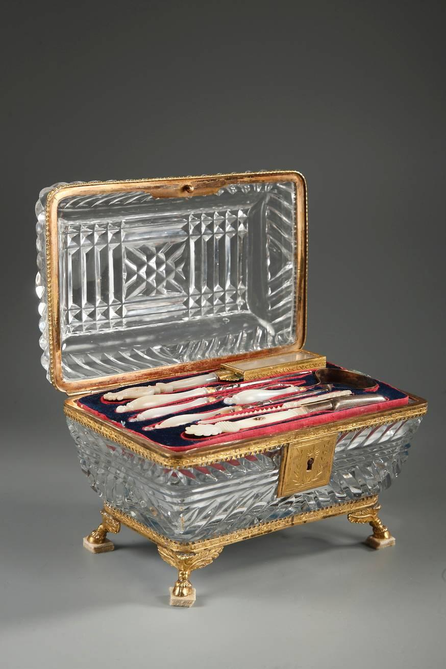 Charles X vanity set in cut crystal with gilt bronze mounts. The crystal is cut into twisting, parallel, and diamond patterns. Inside, a complete set of toiletry items in mother-of-pearl and gilt bronze rests on a velvet tray that hides the double