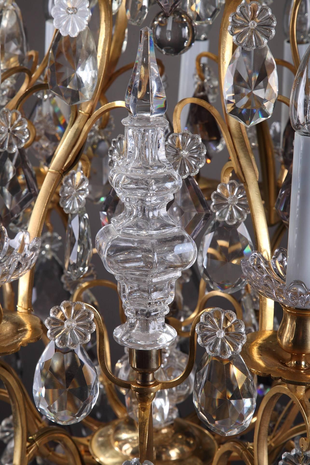 Late 19th century chandelier with 12 curved arms of light richly decorated with drop-hung drippans, slice-cut drops, flowers, balls and daggers in transparent crystal. It has been electrified. Very good condition.


Circa :1890
Dim: W: 23,6 in - D: