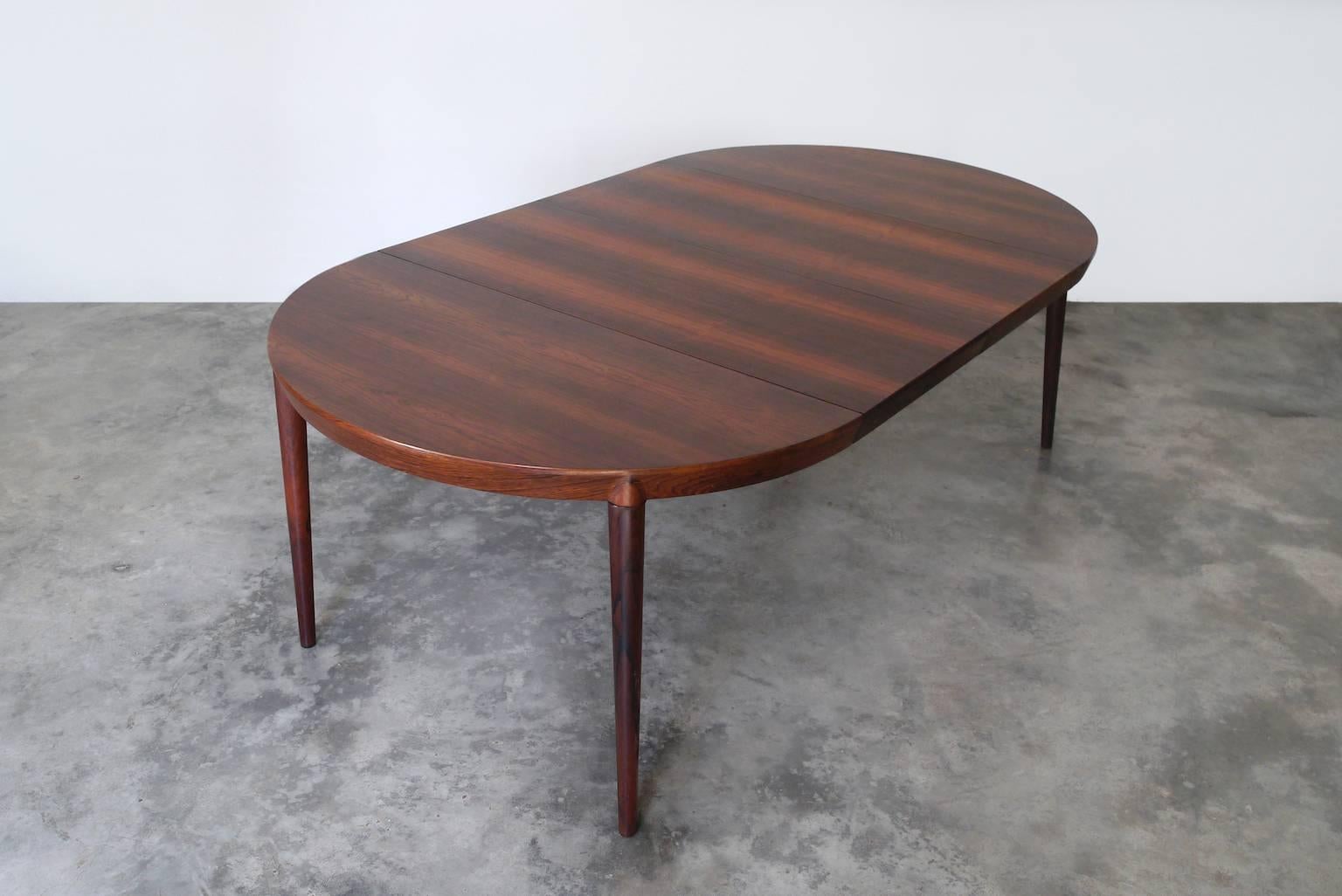 A stunning rosewood dining table (model #71) that features Severin Hansen's signature angled joinery. The richly grained tabletop has a beveled edge that joins seamlessly with each leg. The table can be used with one-two leaves to extend it for up