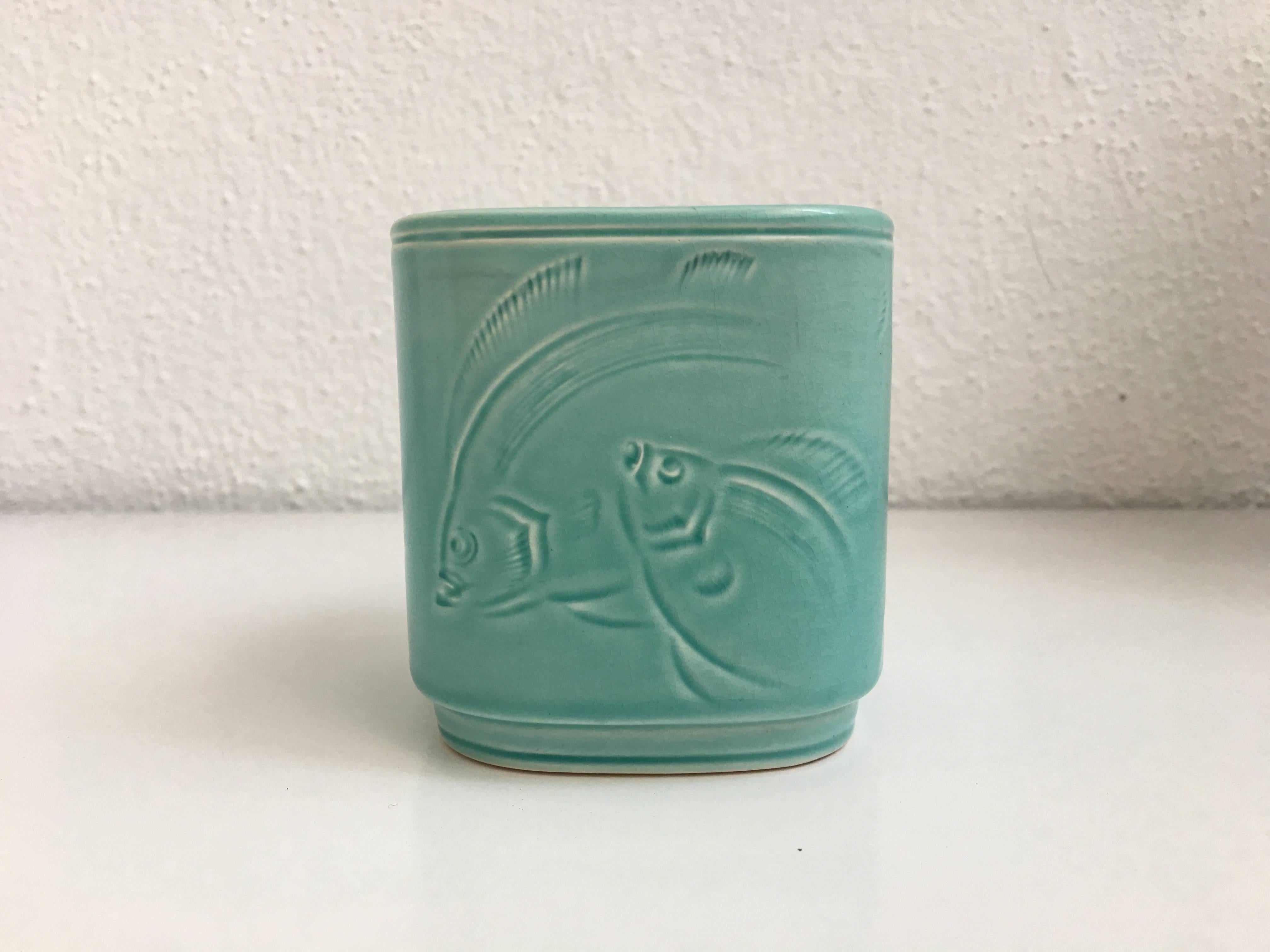 A beautiful rare piece of Aluminia Royal Coppenhagen. This small earthenware vessel has a wonderful aqua glaze and stylized Art Deco fish decoration.

Marked: Denmark 1587.
Incised: 1587.