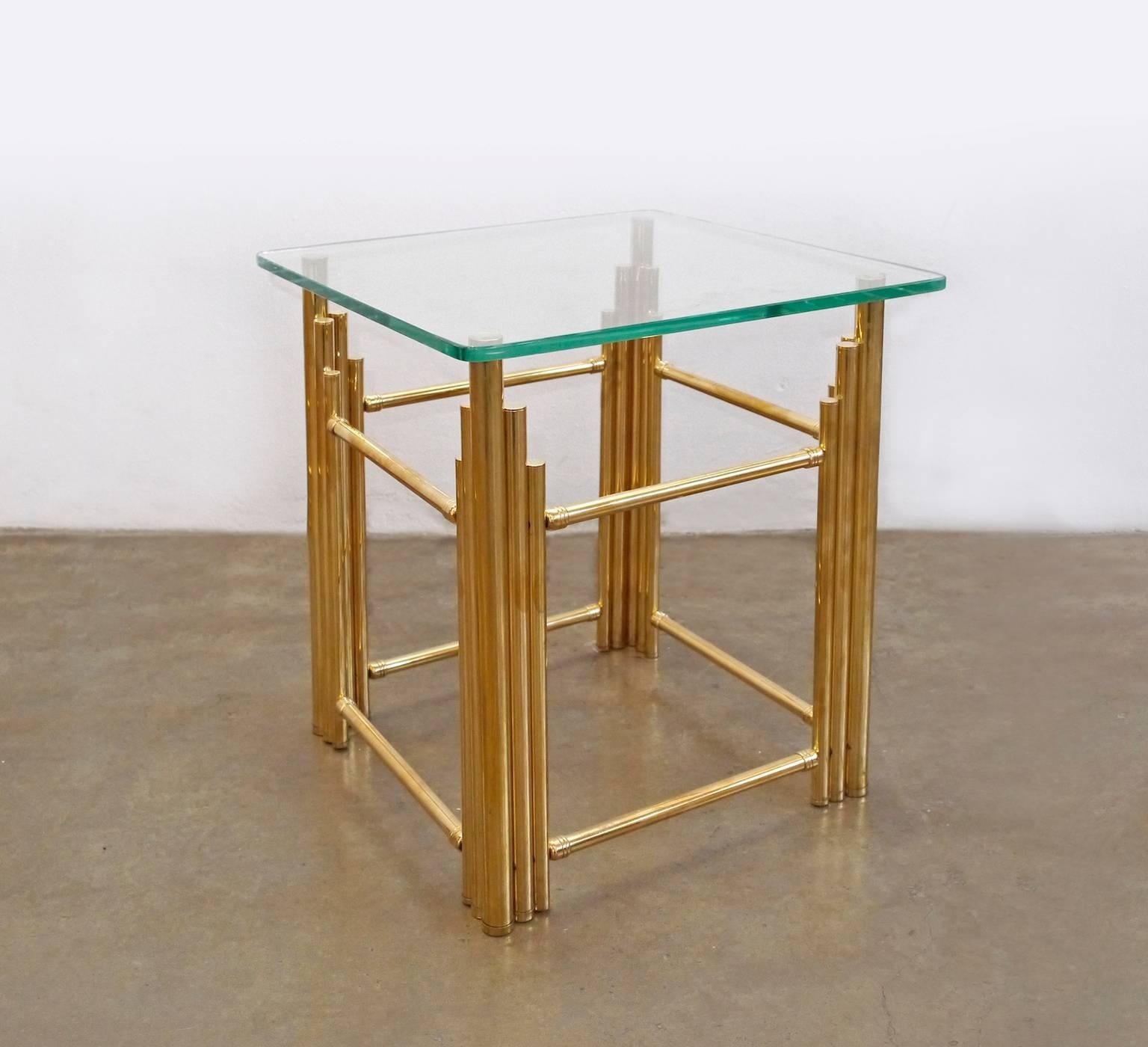 This stylish pair of brass side tables is composed of vertical escalating brass tubes connected by brass stretchers.