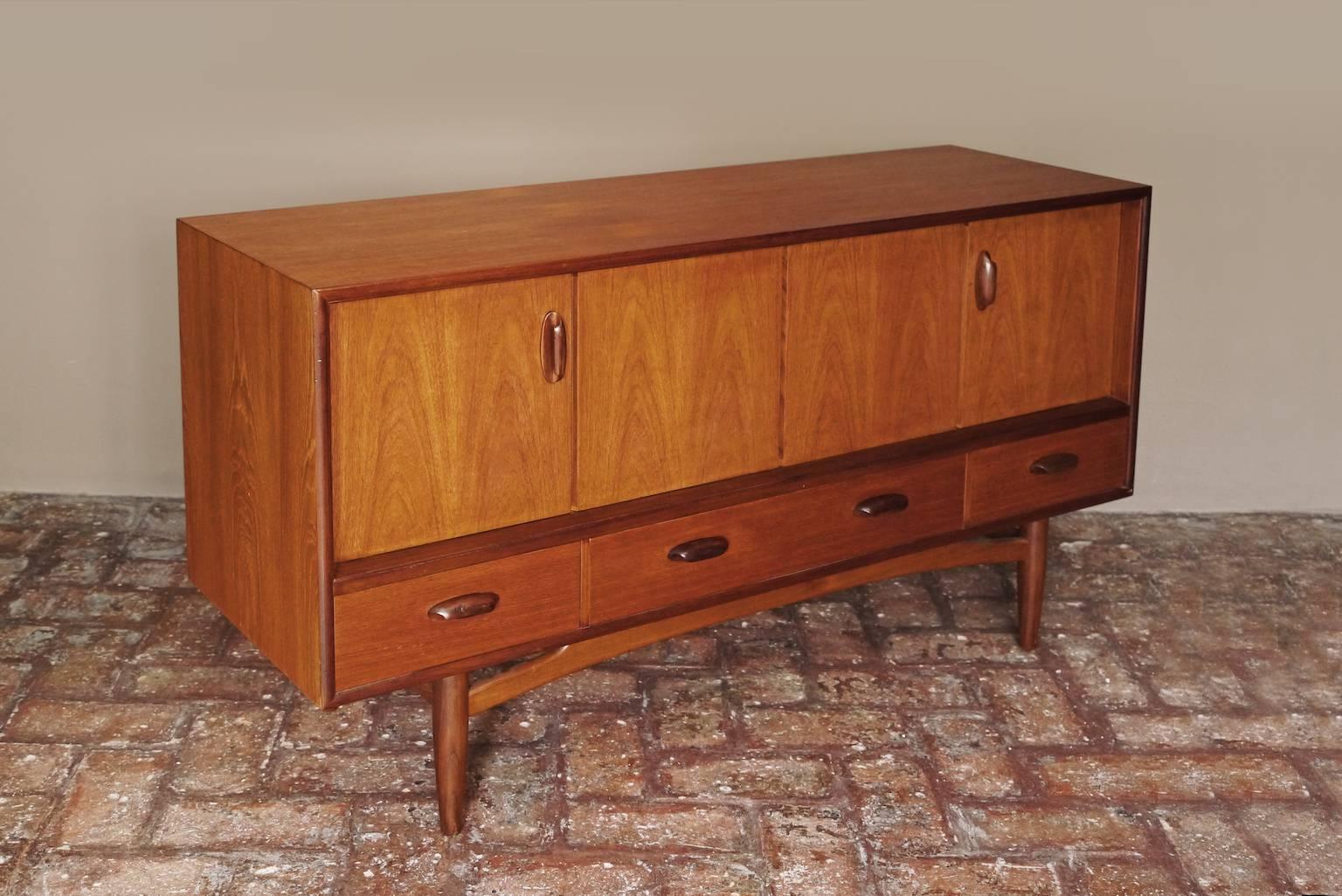 This elegant Scandinavian influenced credenza designed by Victor Wilkins became an instant Classic for G-Plan. An exceptionally well balanced design with dark Afromosia sculpted handles and trim contrasting against the teak veneer. It sits upon an