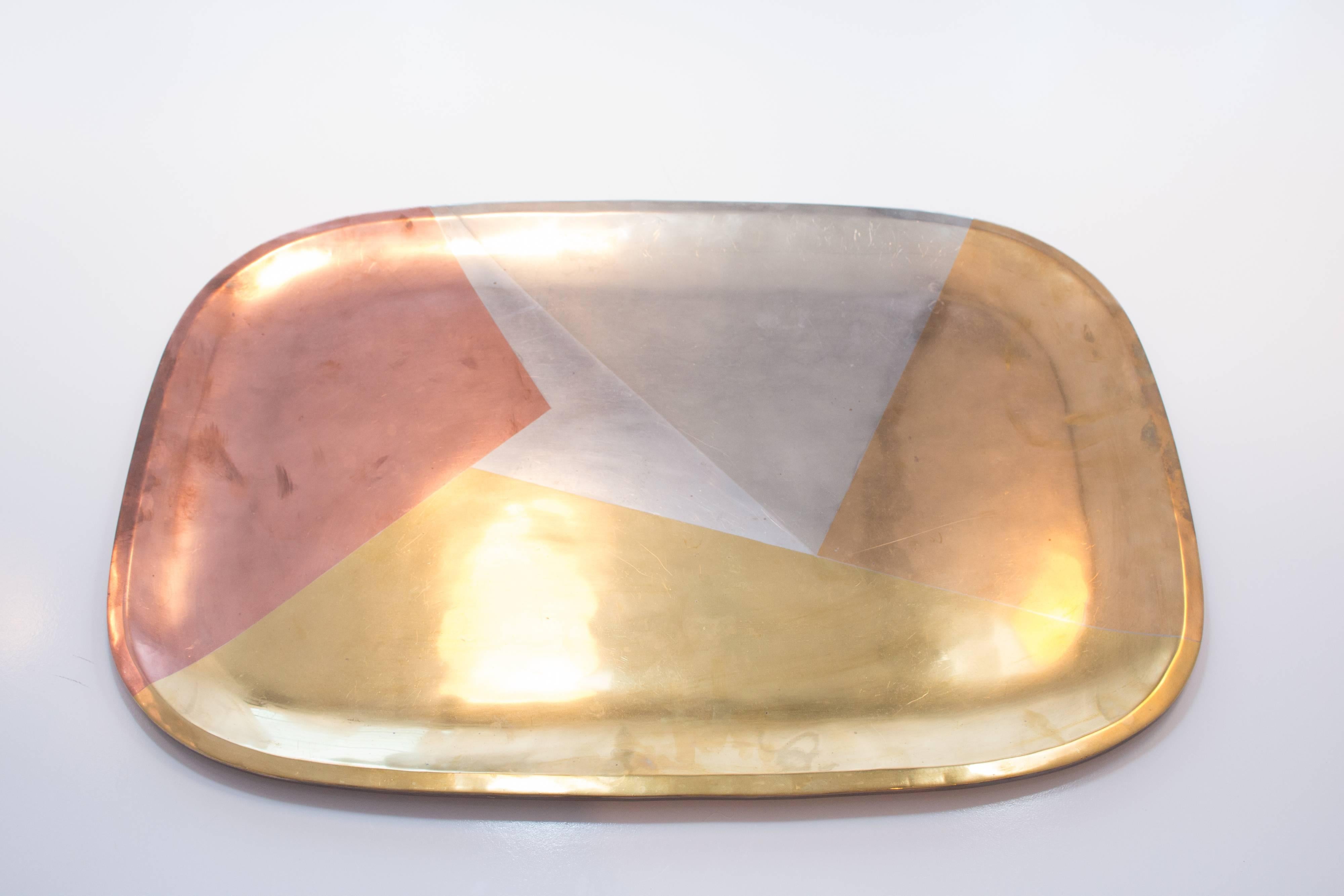 This stunning tray is inlaid with silver, brass, bronze and copper in a geometric pattern. It is the only design of this style that was produced by Taxco after it absorbed Los Castillo. 

Marked underneath.