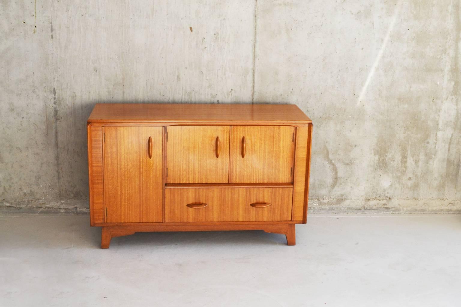 G Plan furniture with the gold ‘E Gomme Ltd’ stamp was produced between 1955-1965. This is a very nice example. Although the size and shape of a chest of drawers, it is a sideboard. A neat detail is a detachable tray that sits inside the cupboard