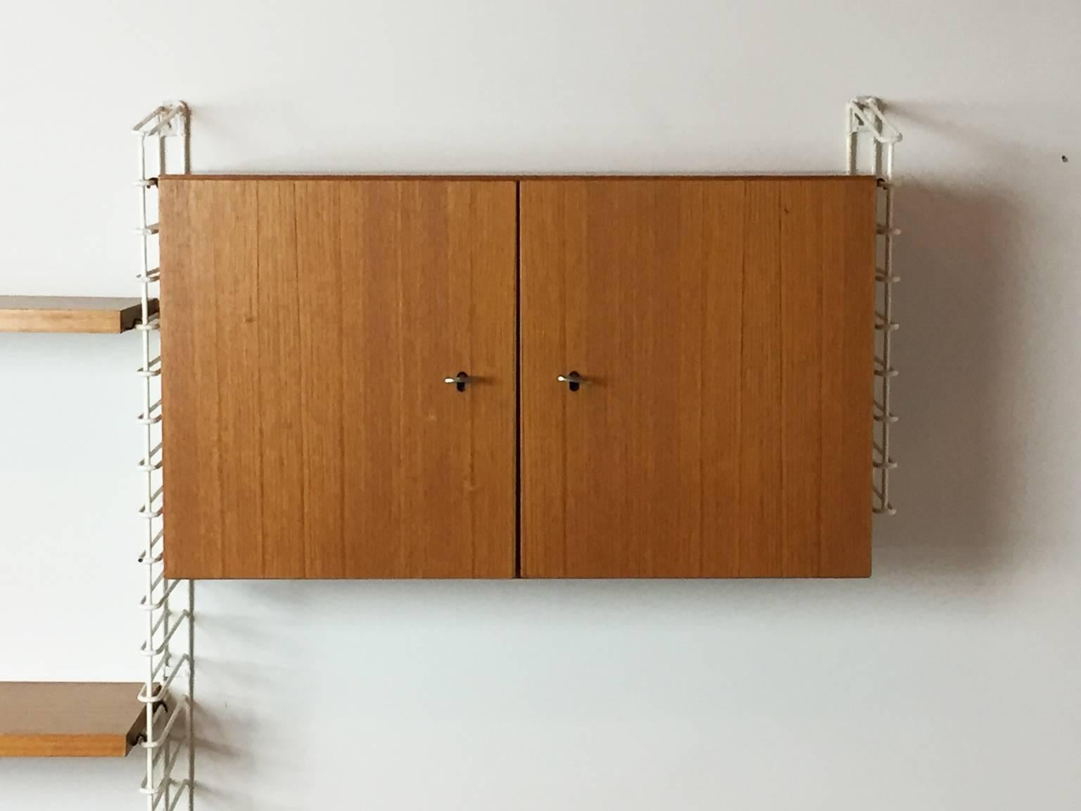 Musterring is a German furniture designer and maker established in 1938 who are still in business today
This is a rare Mustering shelving unit with painted metal supports and teak shelving and cupboard.
Items included:

Six upright support