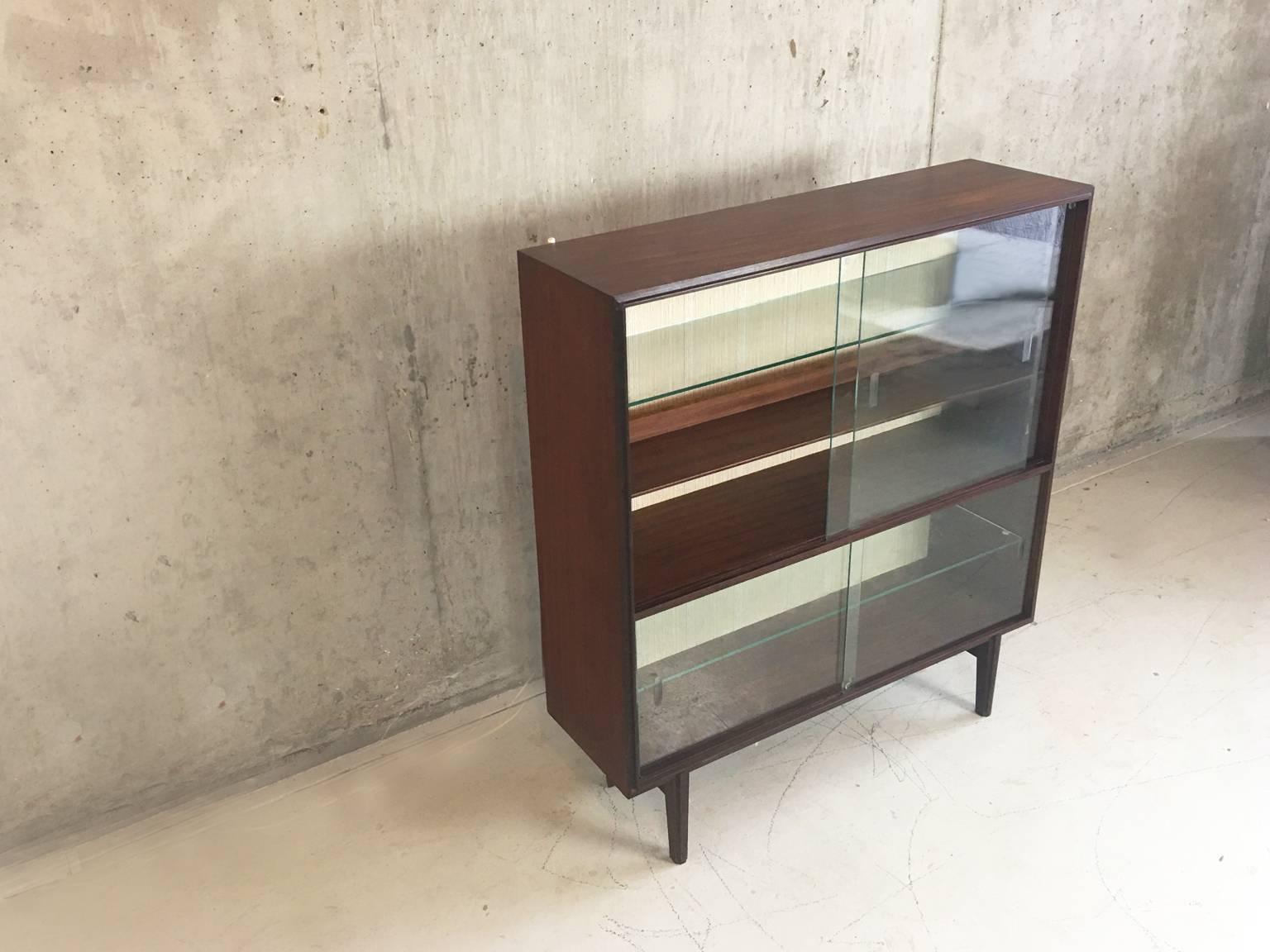 A very stylish dark wood cabinet manufactured by English furniture maker Beaver and Tapley, part of the 'Multi Width' range designed by Robert Heritage. Can be used as a book case, display cabinet or drinks cabinet. The interior of the cabinet is