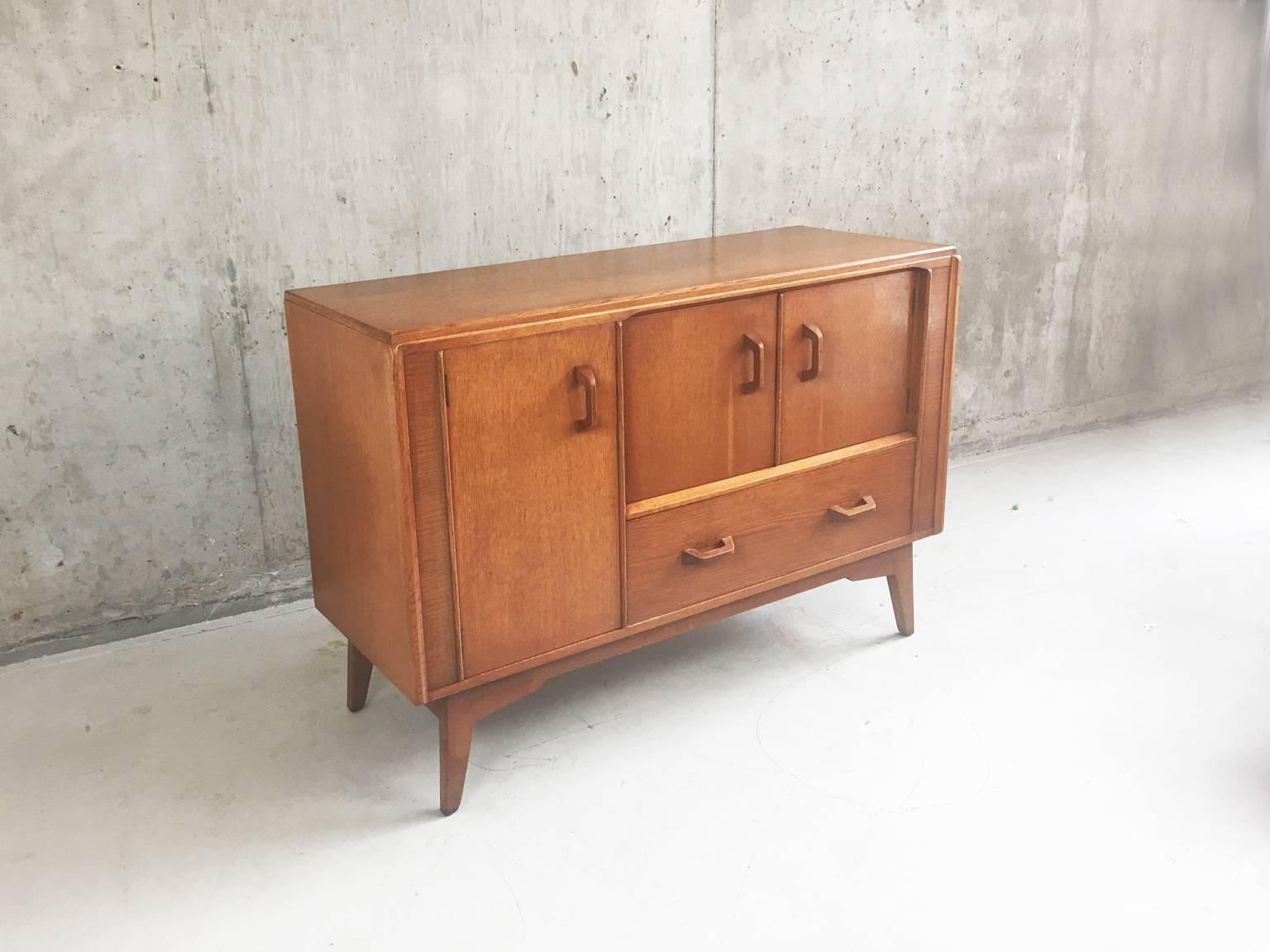 This G Plan E Gomme gold stamped chest of drawers/sideboard/cabinet dates from the 1950s-1960s and is part of the ‘Brandon’ range.

Made of light colored solid oak and oak veneer to the very high E Gomme standards, it is very strong and sturdy and