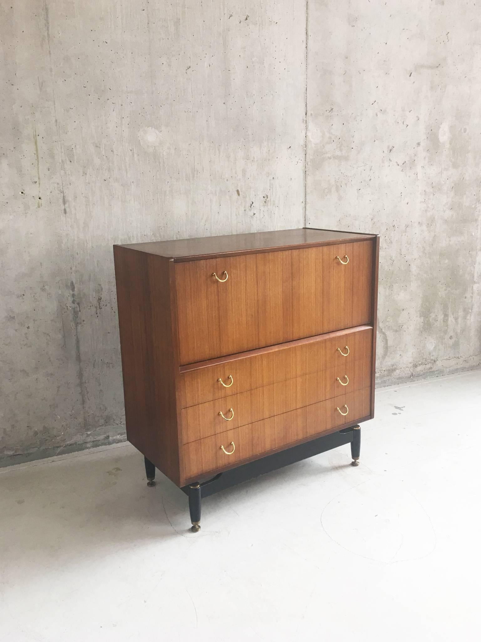 Mid-Century G plan Tola chest of drawers / sideboard / drinks cabinet in good sturdy condition. Standing on elegantly shaped ebonised legs with brass feet that are typical of the Tola range. this chest is in great vintage condition. 

 