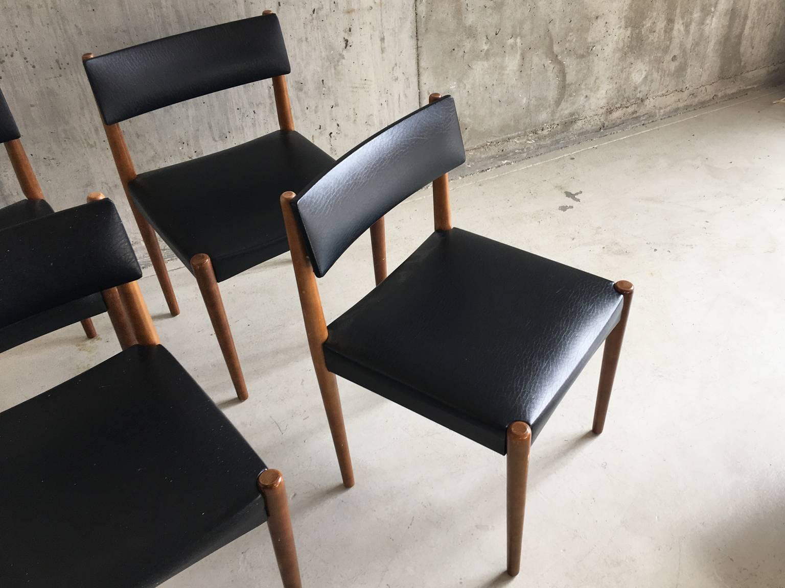 Stylish set of four chairs with teak frames and original subtly textured black vinyl cushioned upholstery. A nice detail is the slightly raised bottom part of the backrest.

The price is for all four chairs.
 