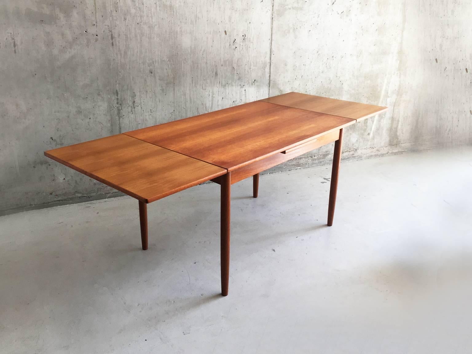 This drop-leaf extendable teak dining table was made by A.B.J of Denmark, the design is typically Danish modern, sleek, elegant and simple. The table extends to comfortably seat 6 or 8. The original stamp is on the underside of the table.

 
 