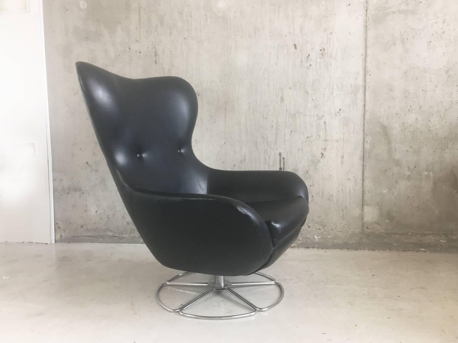 This is very large beautifully curved armchair, upholstered in the original thick black textured vinyl. It’s in fantastic condition and very, very comfortable.