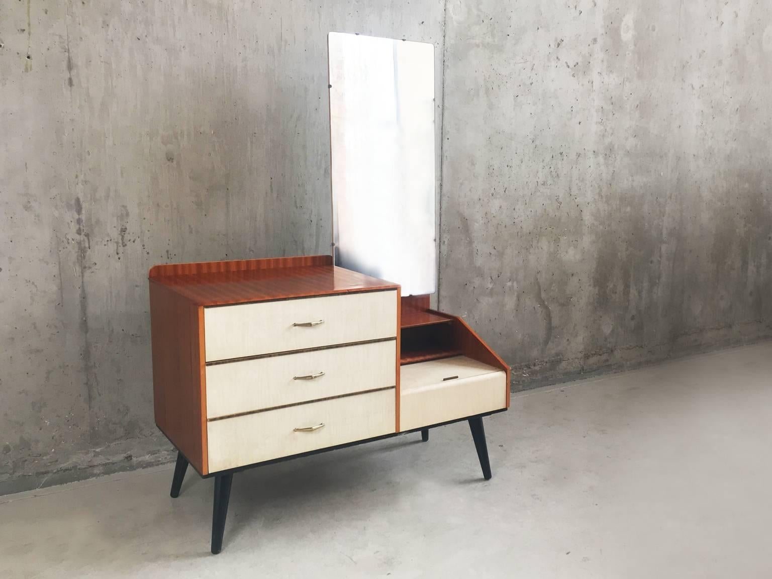 A very cool small chest of drawers with full length mirror, finished in teak laminate with white laminate door fronts with brass plate handles.

 