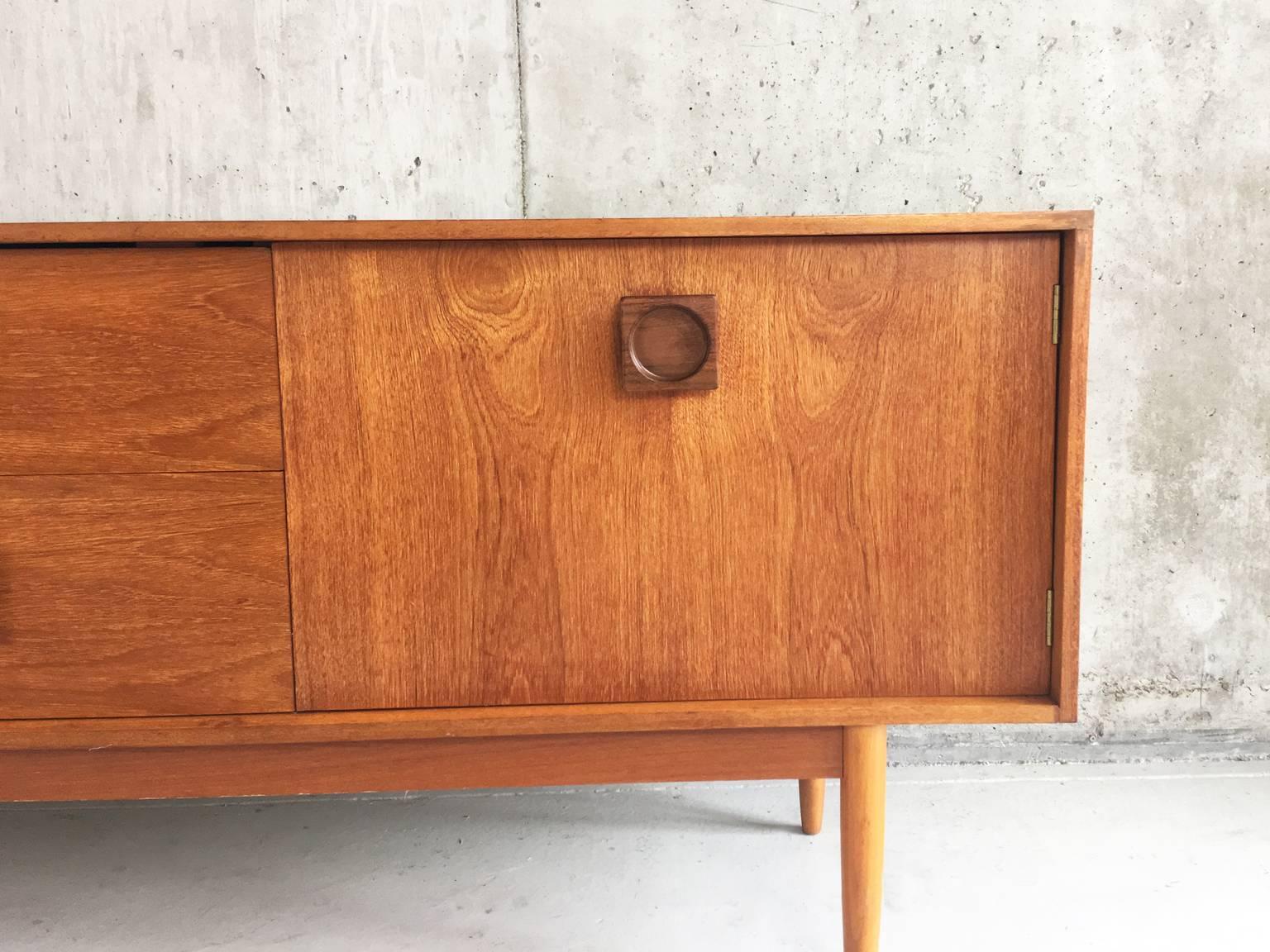 The fantastic wood grain makes this piece outstanding. The design is simple, minimal and elegant with darker teak square handles with a round inset. The only fault is that the top middle drawer is not on a runner properly, when pulled out it stays