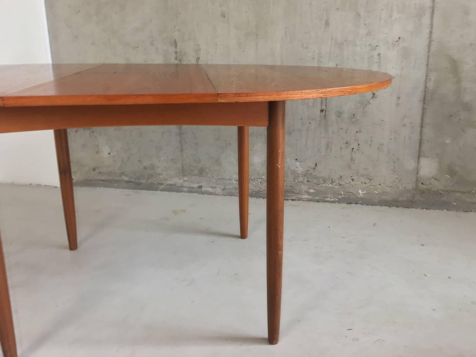 A solid teak original extendable G plan table with lovely wood grain. The table is very well made and substantial with a fold down central section. Original G plan sticker on underside of flap.