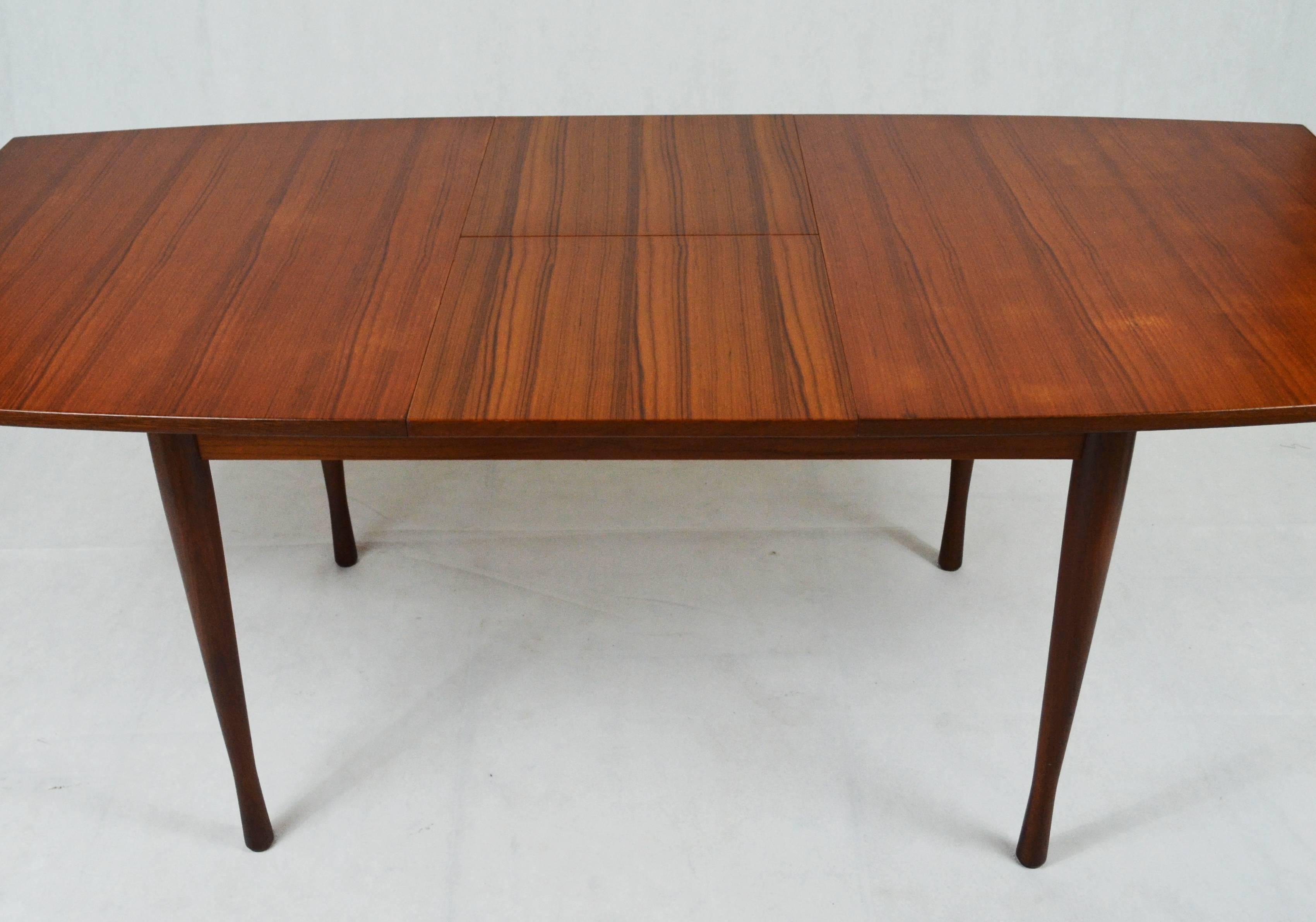 Swedish style extensible table, Italy, 1960s. Teakwood, divided in the middle to permit the table to be open when needed. The extensions are in teakwood as well and they are folded under the top. All the body and the legs are made of teakwood.
It