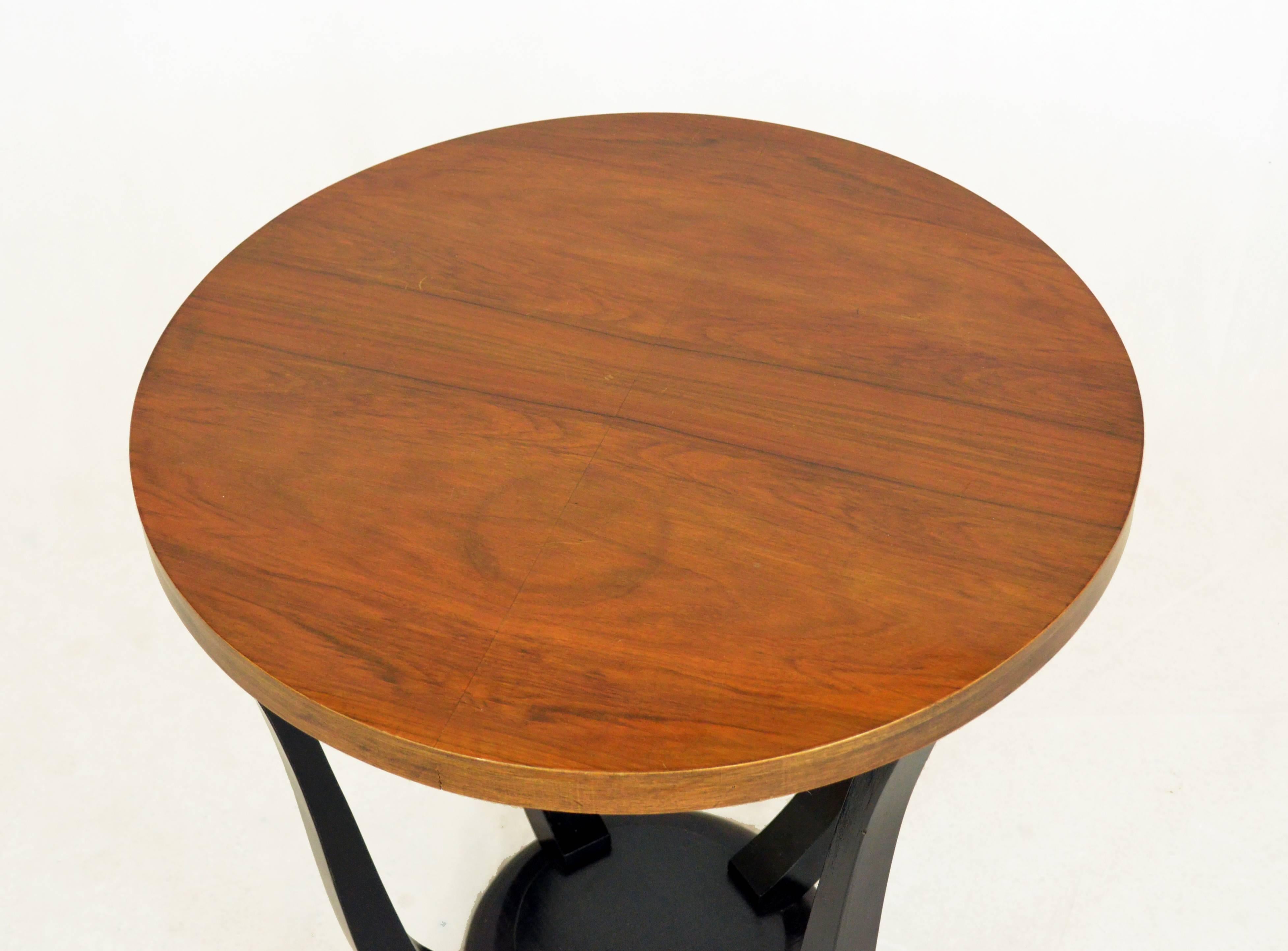 A small ductile Art Dèco gueridon, from France, from 1920s.
The table has ebonized legs which connect the top which is in natural nutwood. Conservative restoration consisted in renewing the polish of shelves and retouching the ebonized parts. Size